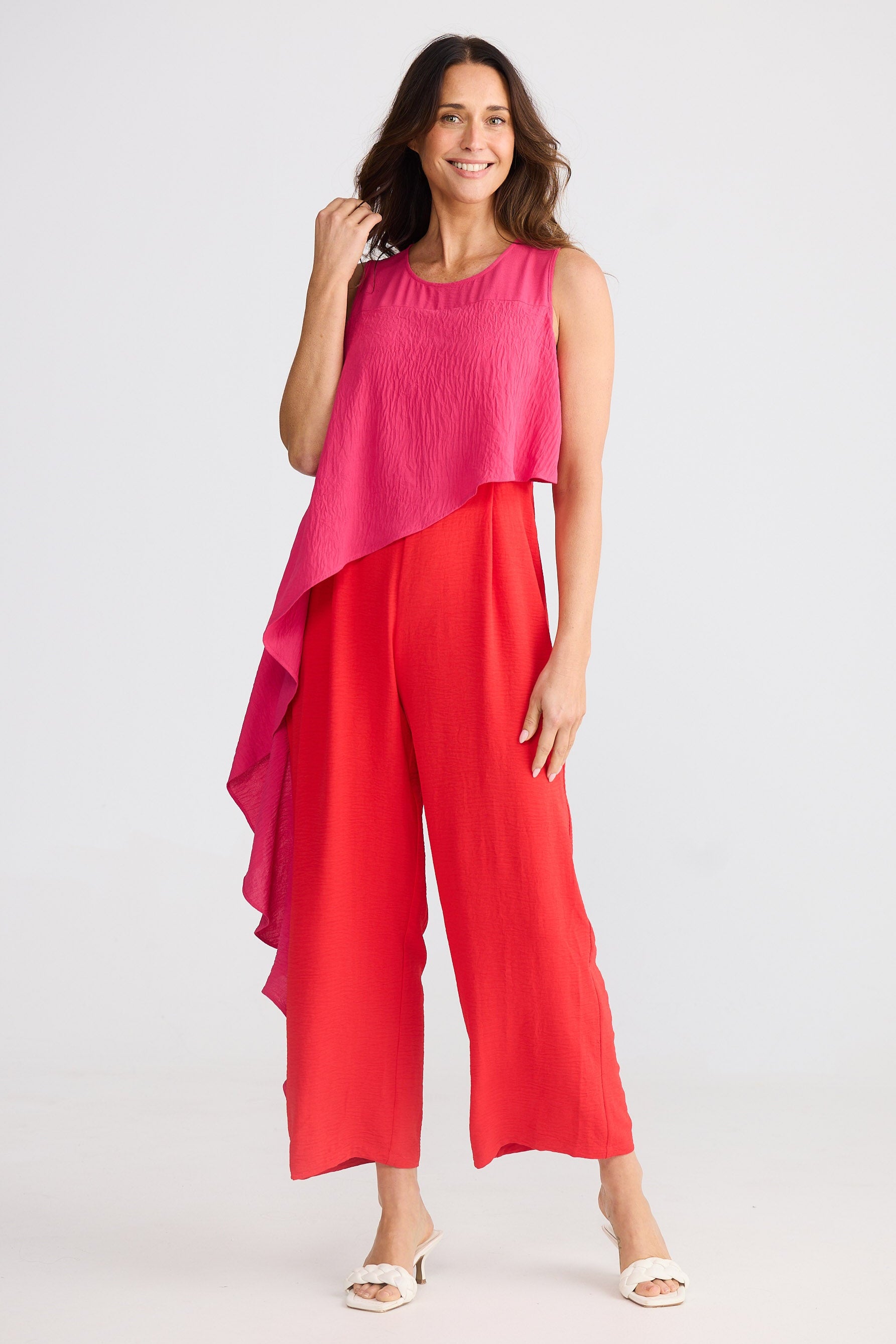 Woman wearing a pink and red pantsuit on a white background