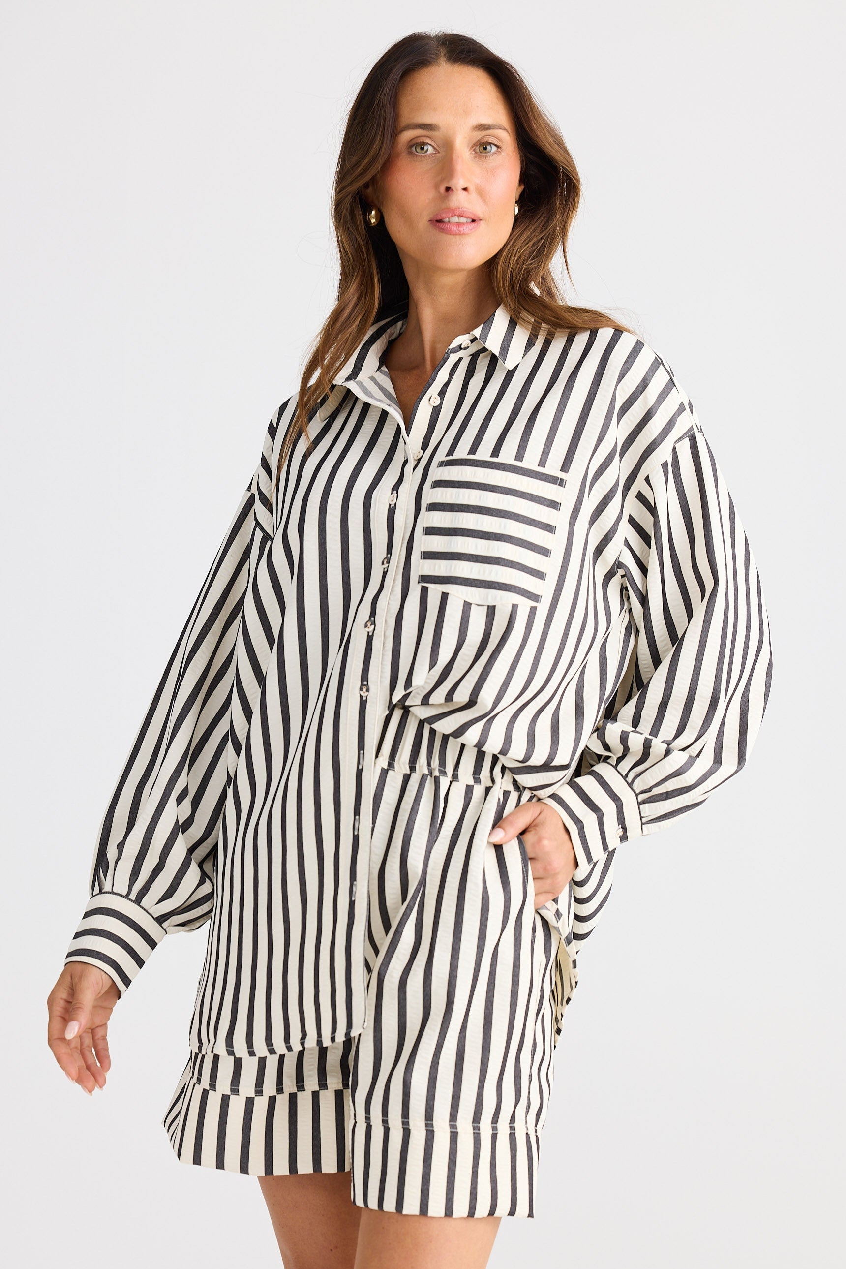 Woman wearing a black and white striped dress against a plain background