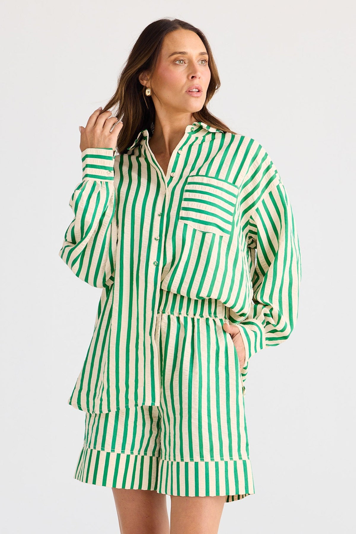 Woman wearing a green and white striped outfit on a white background