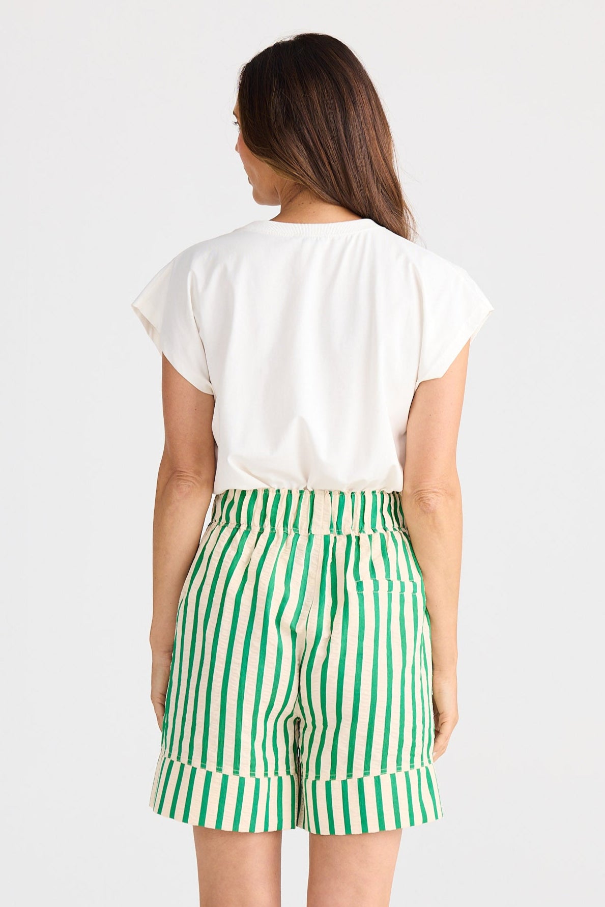 Person wearing green and white striped shorts on a white background