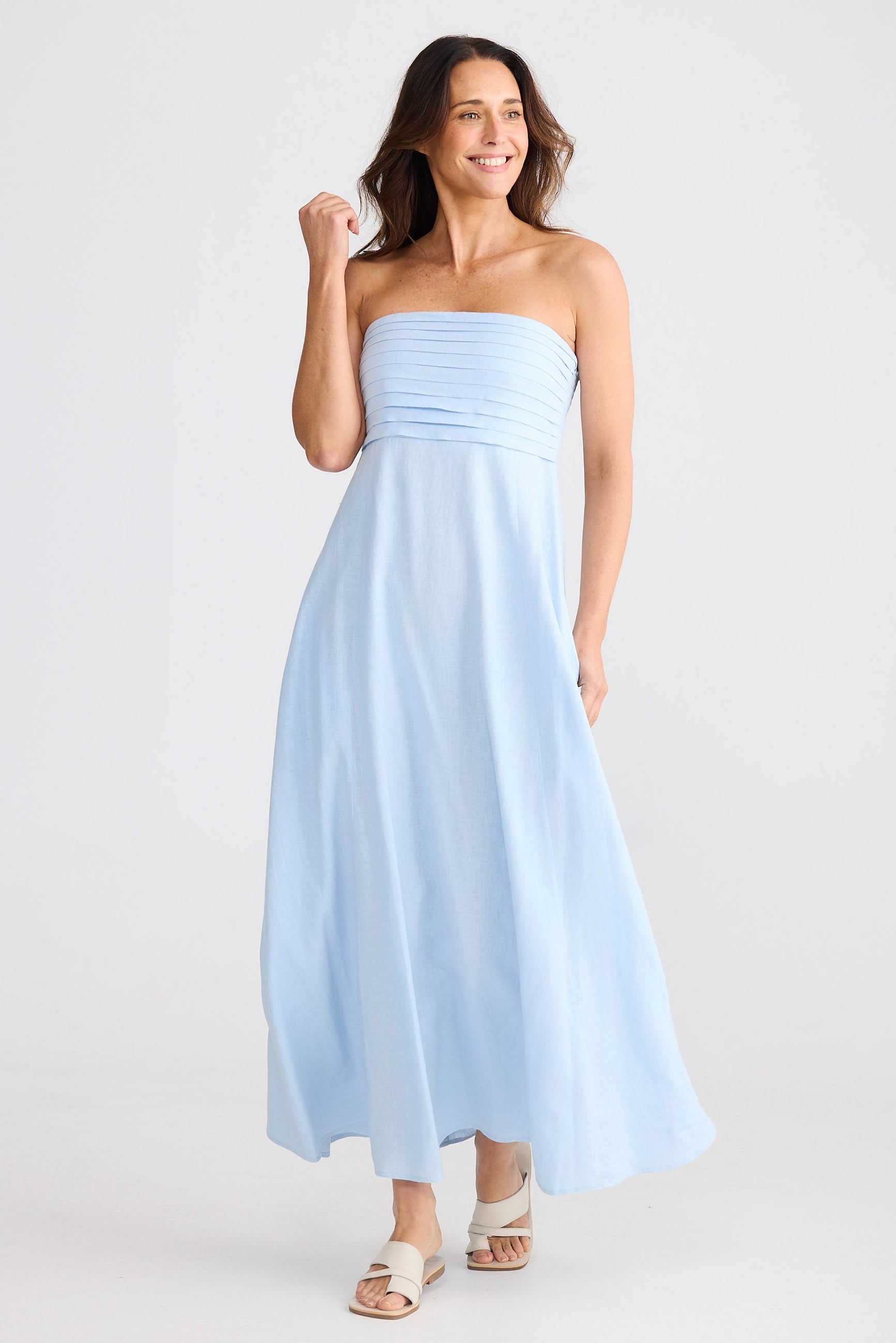 Woman wearing a light blue strapless dress on a white background