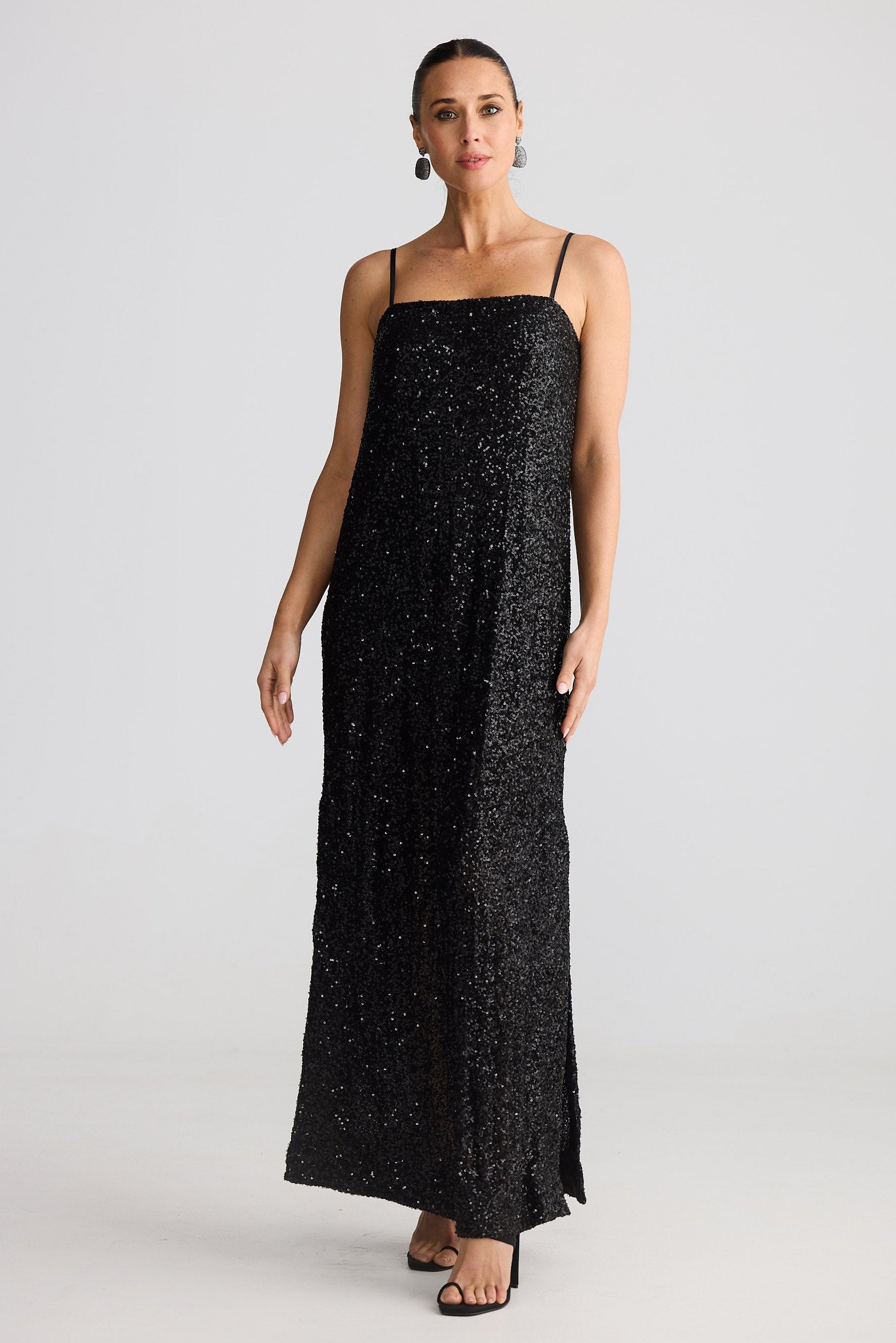 Woman wearing a black sequin dress on a white background