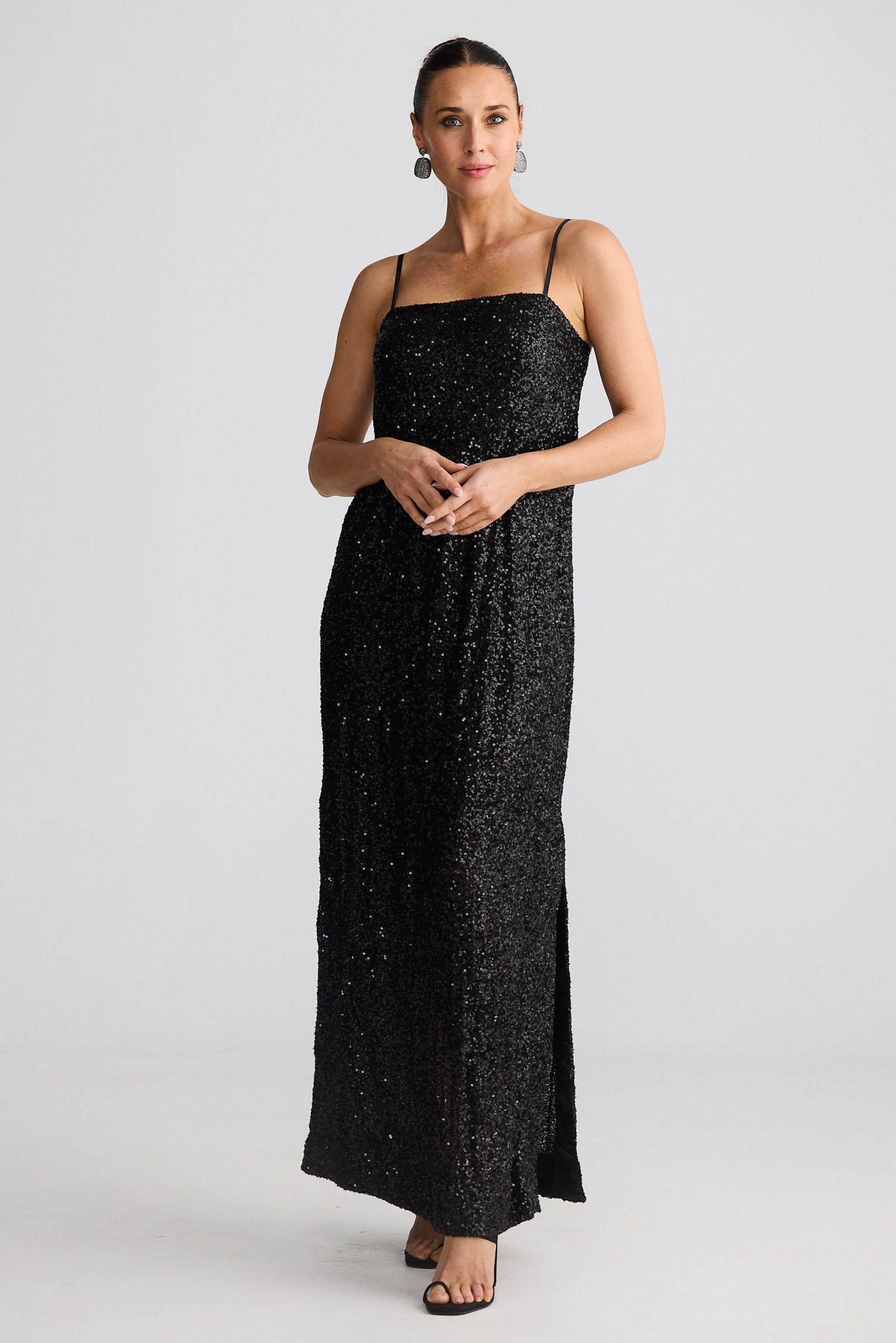 Woman wearing a black sequin dress on a white background
