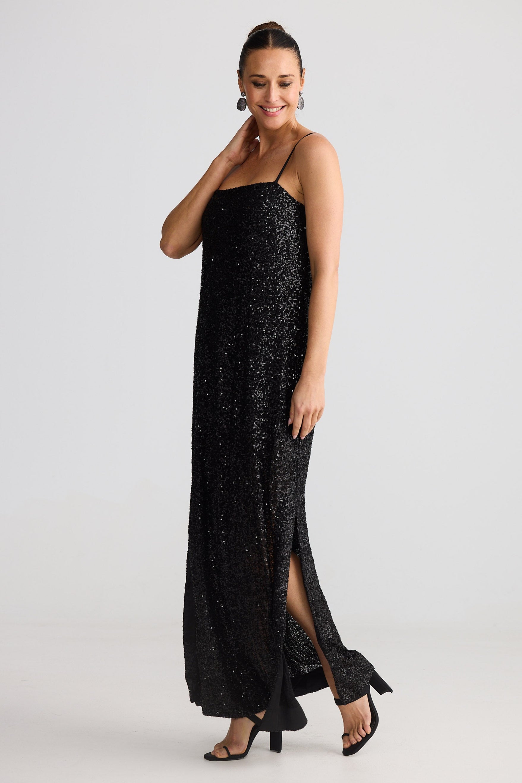 Woman wearing a black sequin dress on a white background
