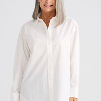 Woman wearing a white blouse against a white background