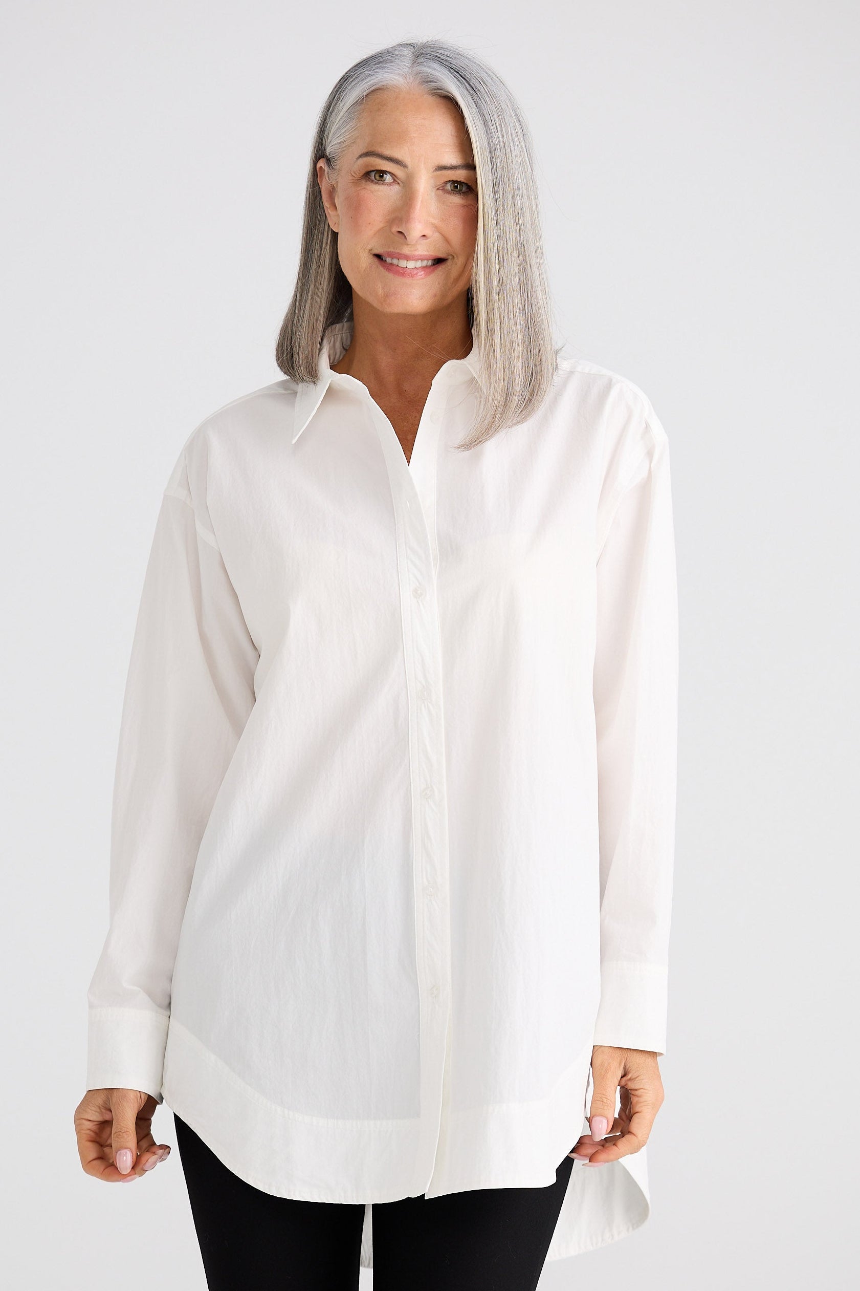 Woman wearing a white blouse against a white background
