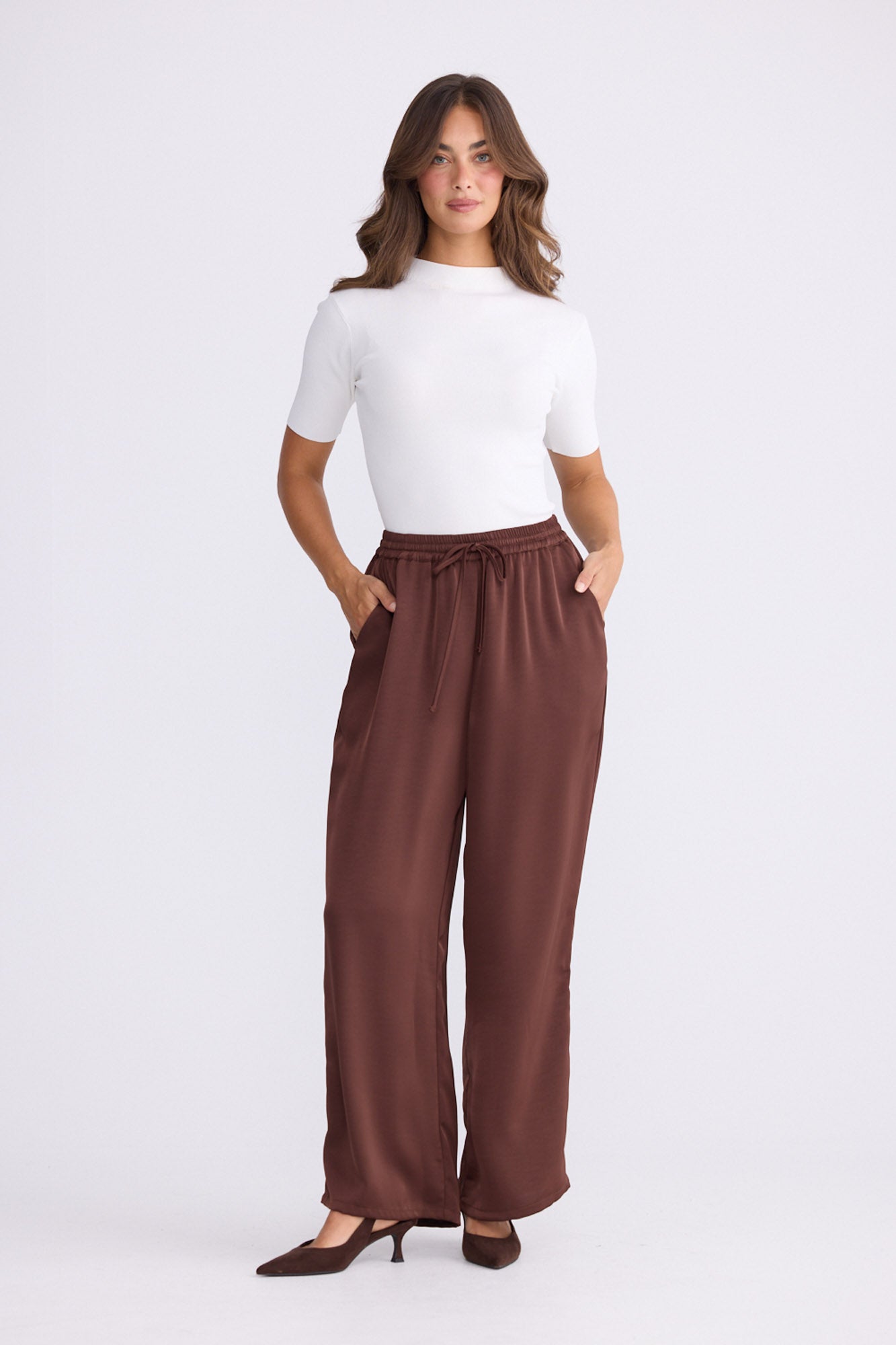 Model wearing Glenda Pant brown pants, straight-leg fit, alternate studio view on white background