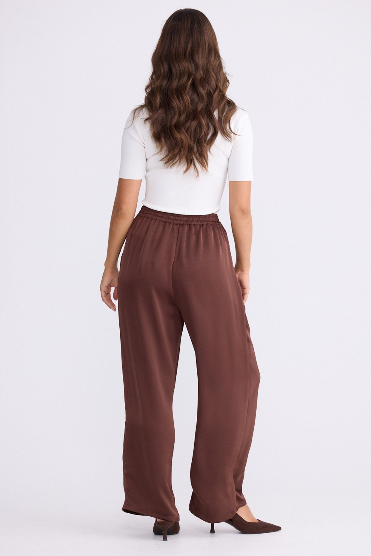 Model wearing Glenda Pant brown pants, straight-leg fit, alternate studio view on white background
