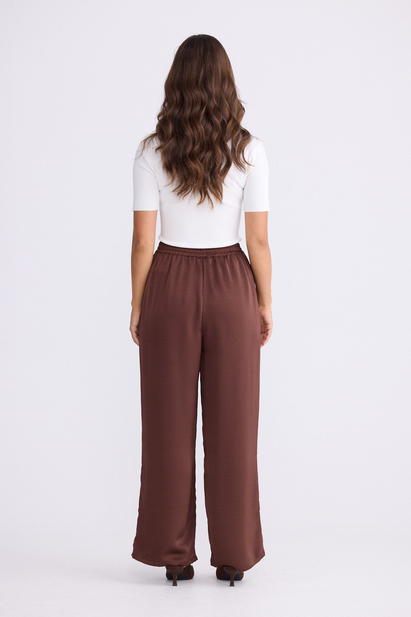 Model wearing Glenda Pant brown pants, straight-leg fit, alternate studio view on white background