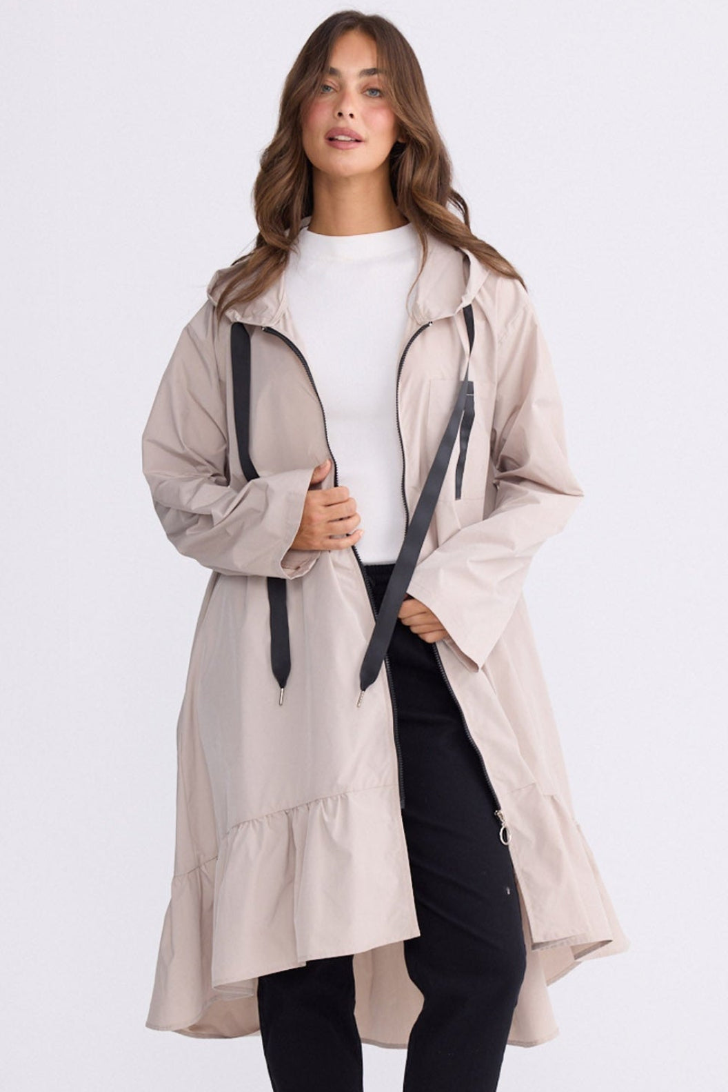 Model wearing Hyacinth Raincoat in beige with hood and long sleeves, front view on white background