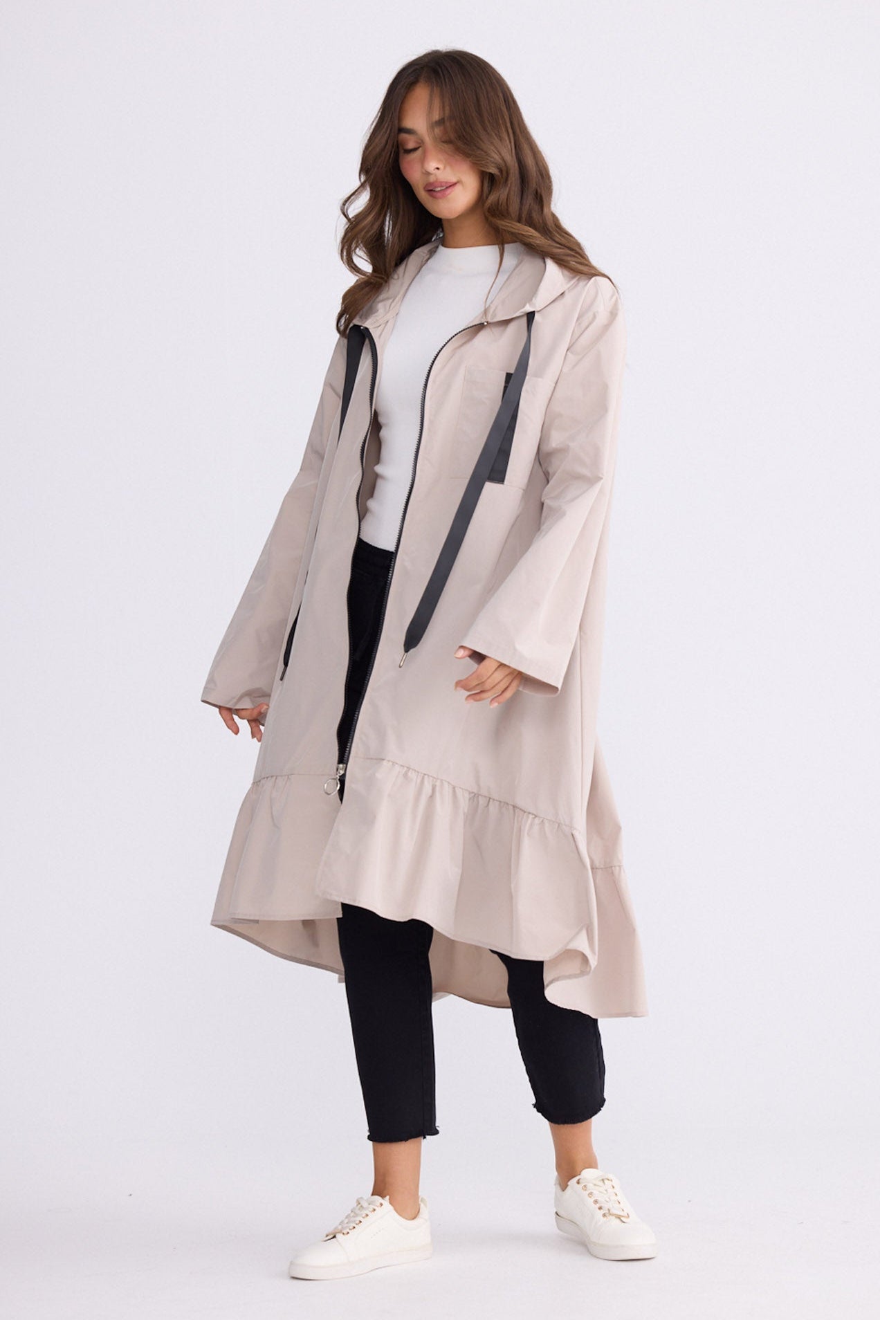 Model wearing Hyacinth Raincoat in beige with hood and long sleeves, front view on white background