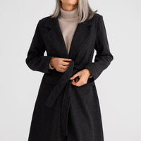 Woman wearing a black coat on a white background