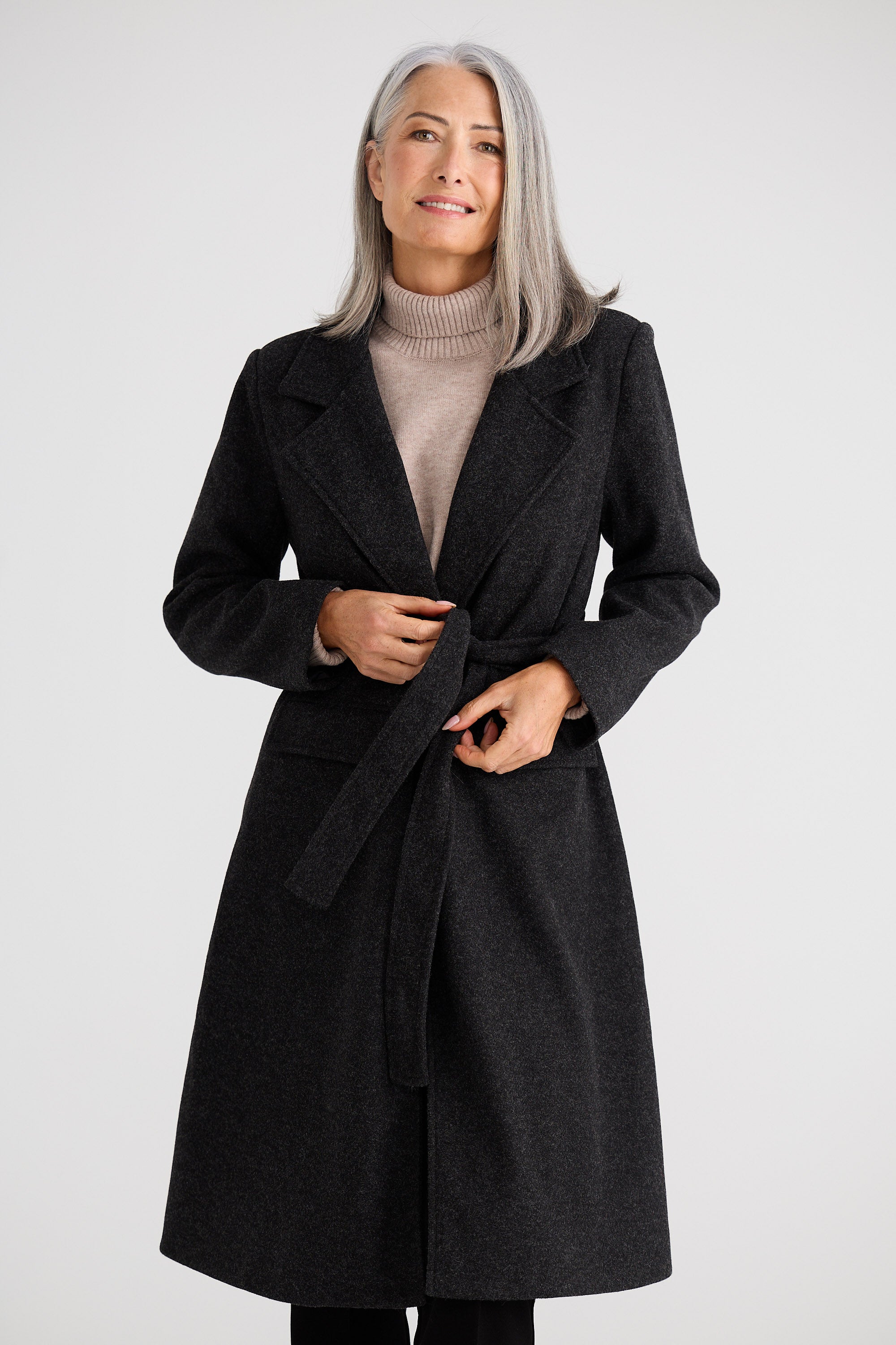 Woman wearing a black coat on a white background