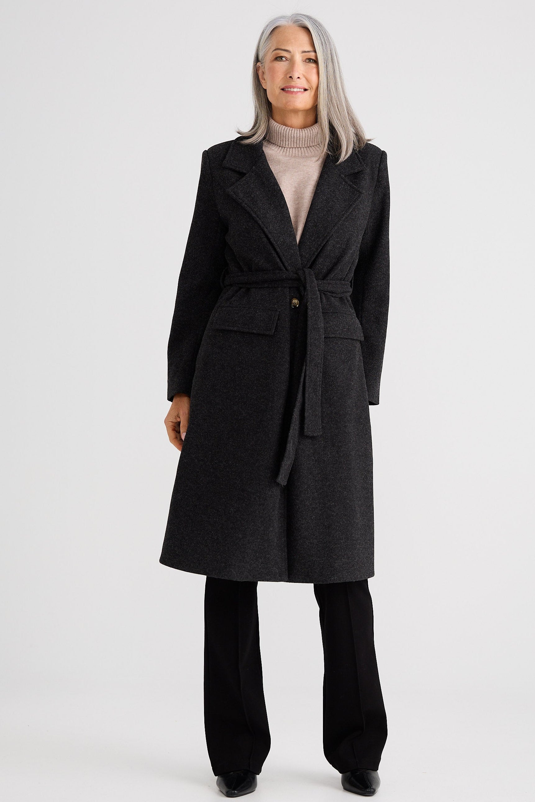 Woman wearing a dark gray coat on a white background