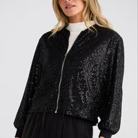 Woman wearing a black sequin jacket on a white background