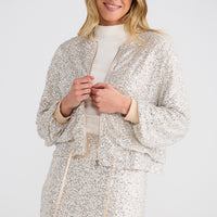 Woman wearing a silver sequin outfit against a white background