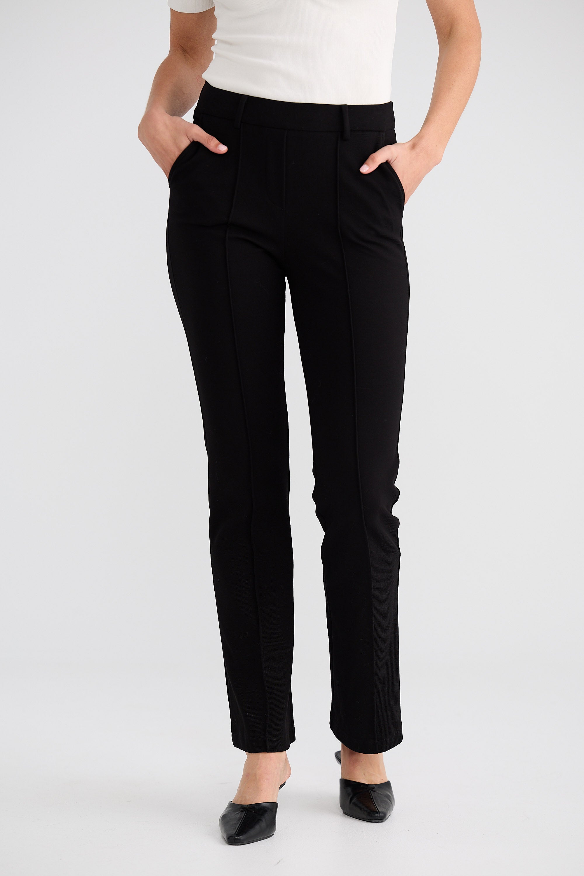 Black pants worn by a person on a white background