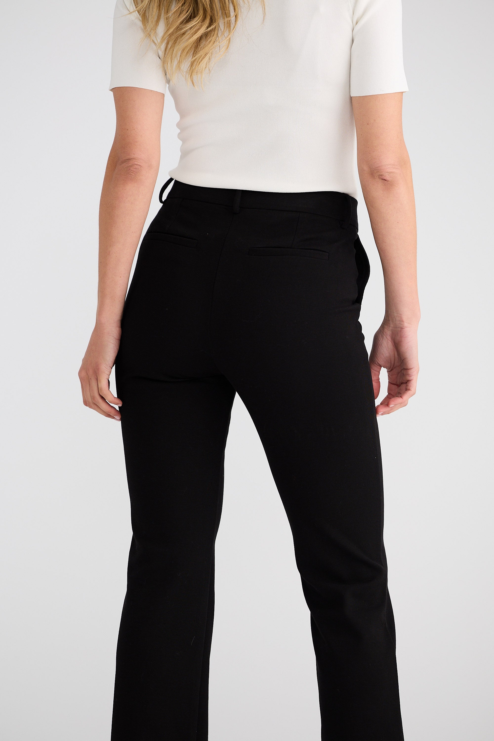 Person wearing black pants on a white background