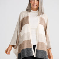 Woman wearing a striped poncho against a white background