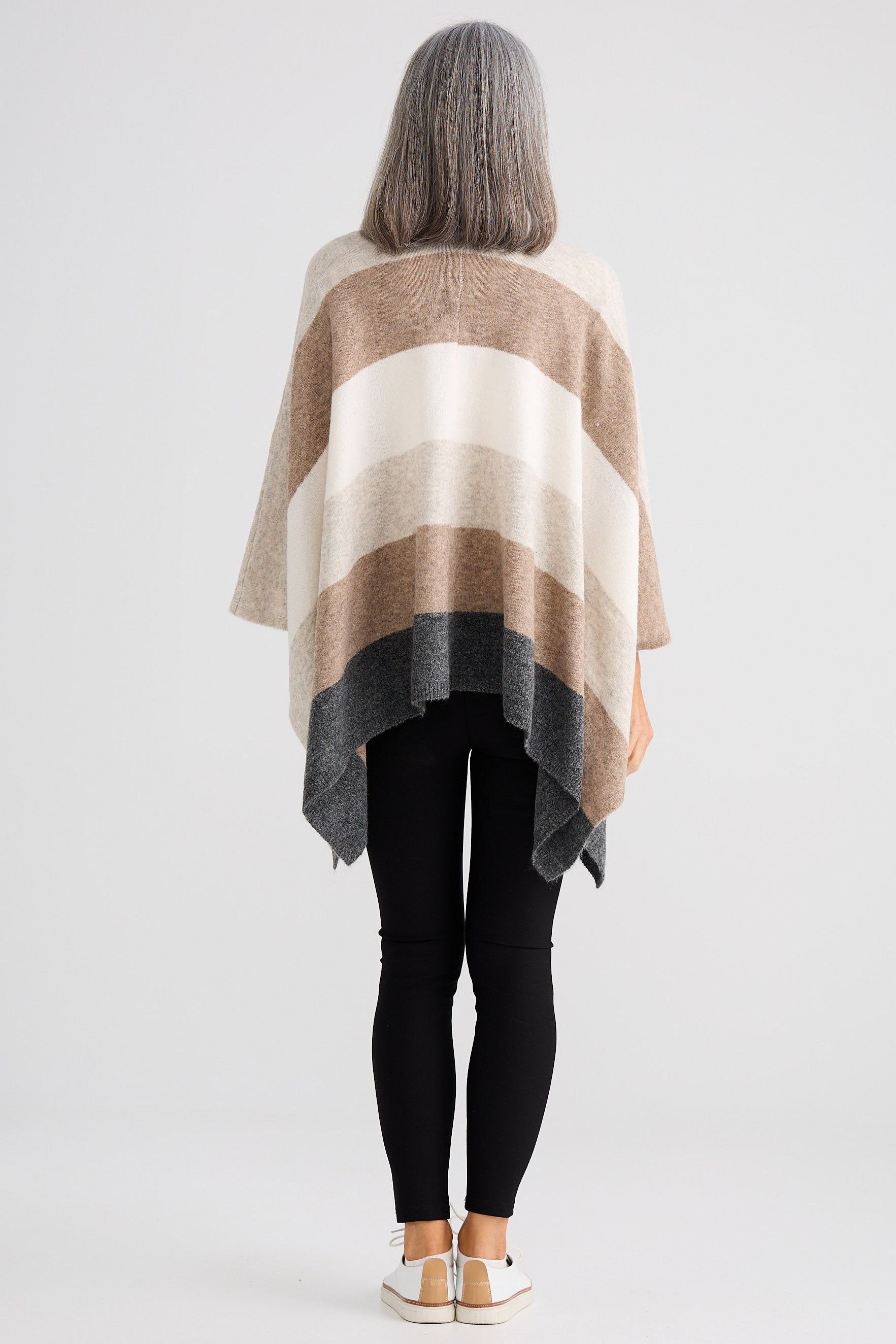 Person wearing a striped poncho on a white background