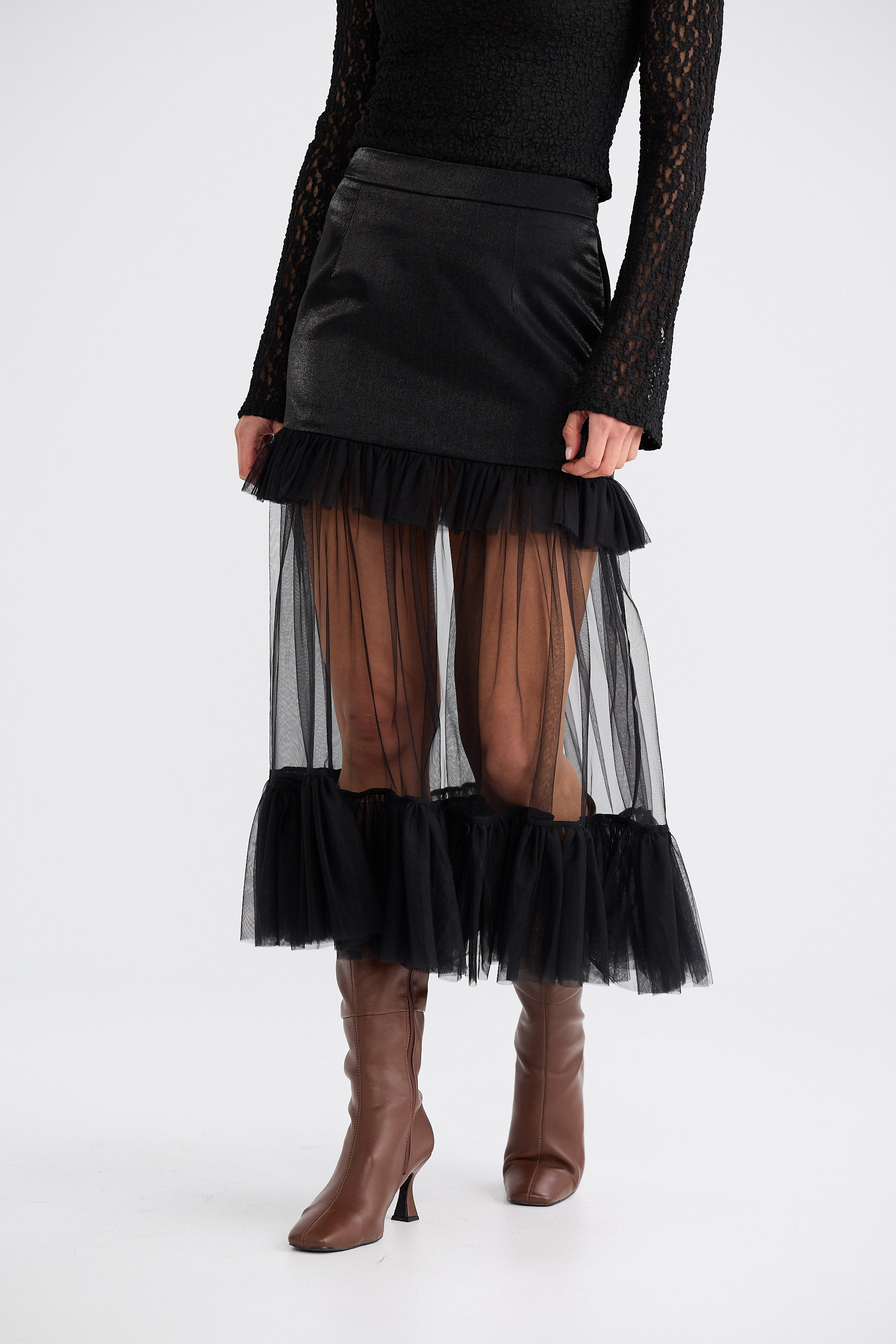 Black skirt with sheer layers worn by a person on a white background
