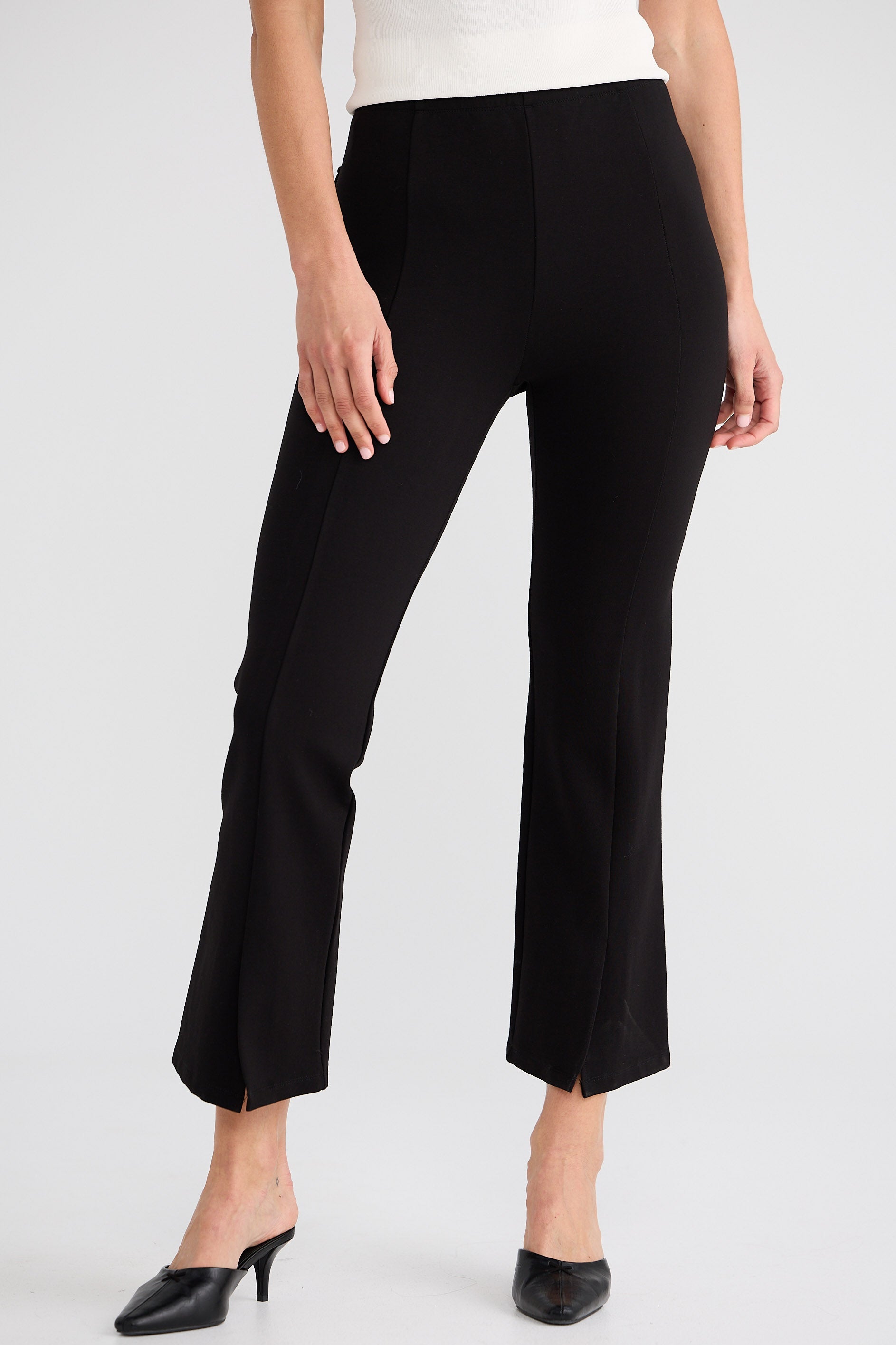 Black pants worn by a person on a white background