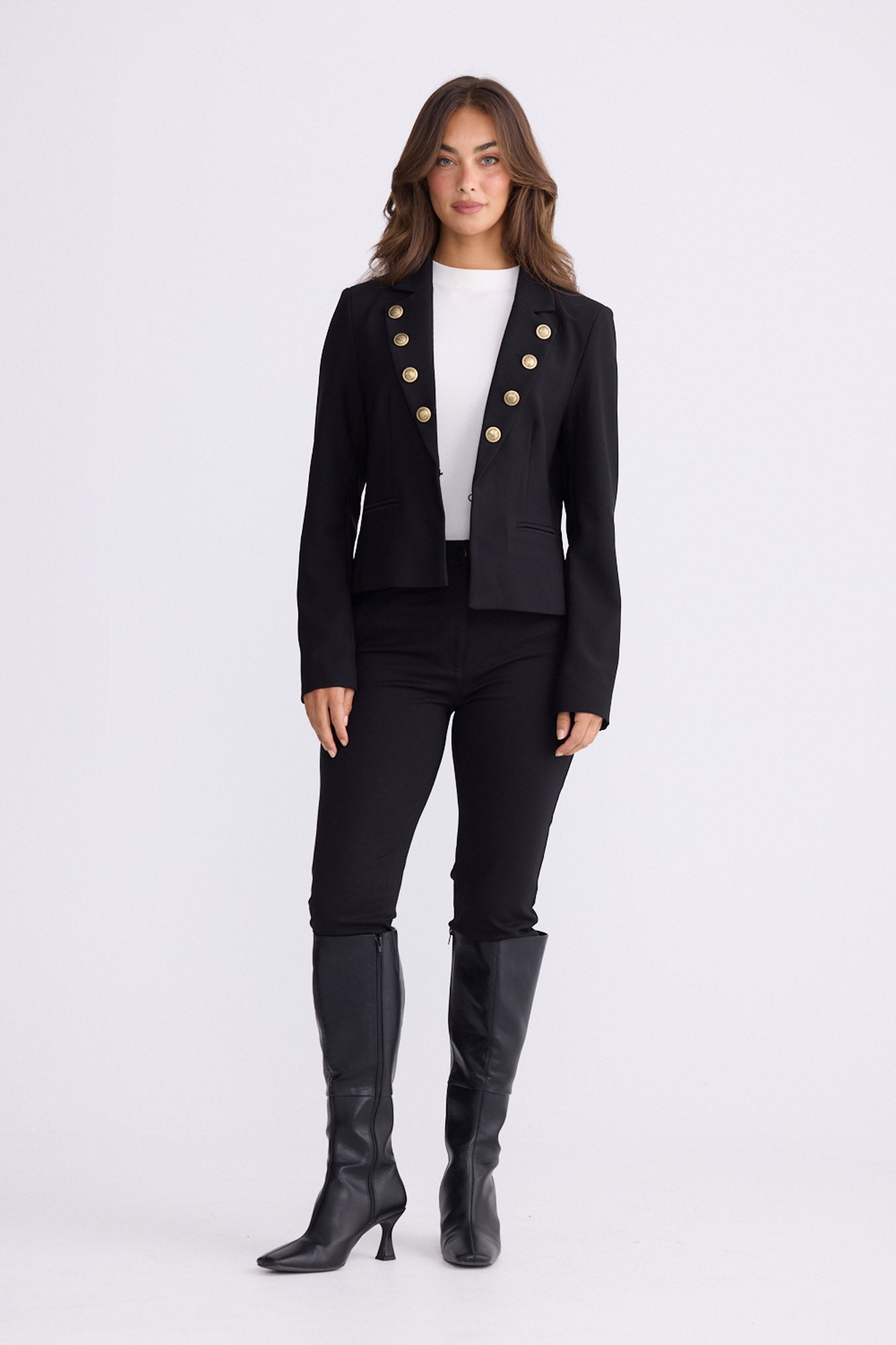 Model wearing St James black blazer with gold buttons and notched lapels, front view on white background