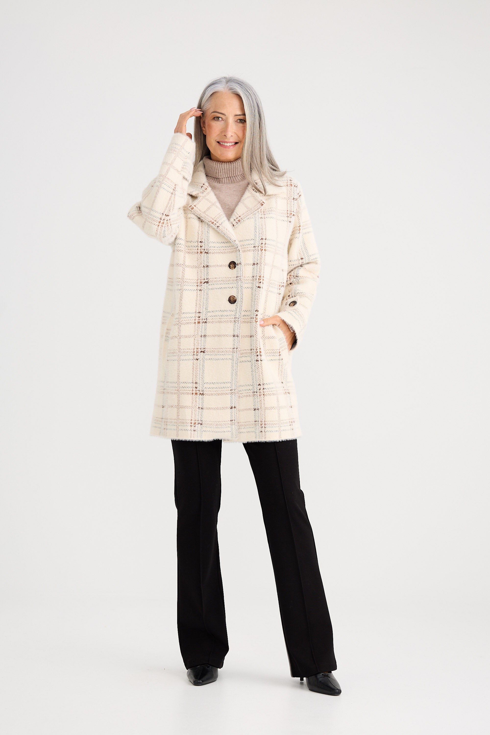 Woman wearing a checkered coat on a white background