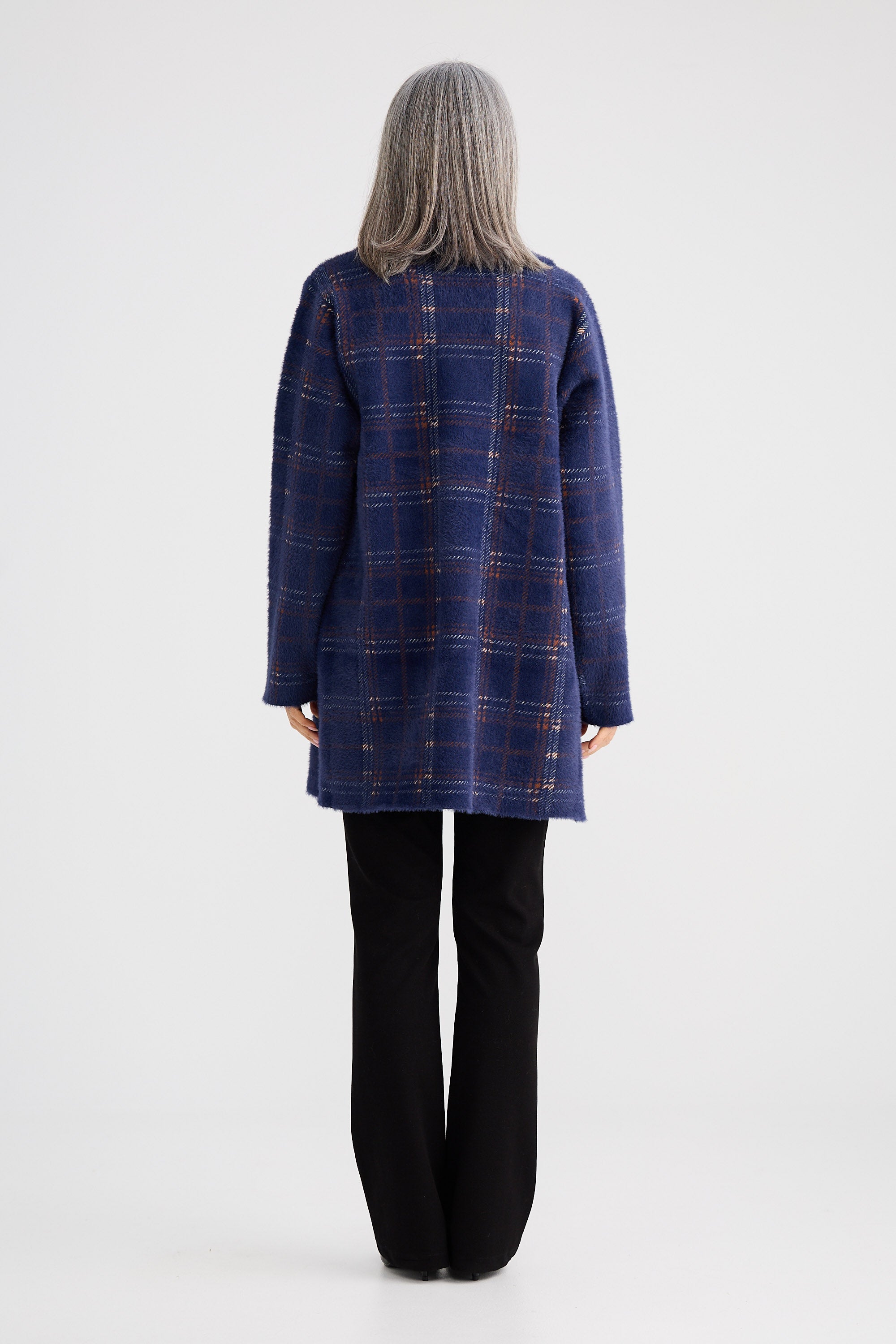 Person wearing a blue plaid coat on a white background