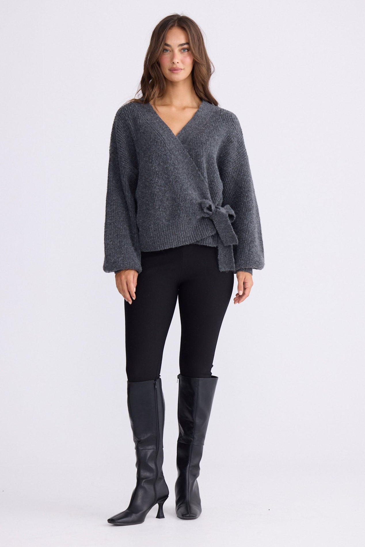 Model wearing Monteith Wrap Knit in grey with V-neck and wrap front, front view on white background