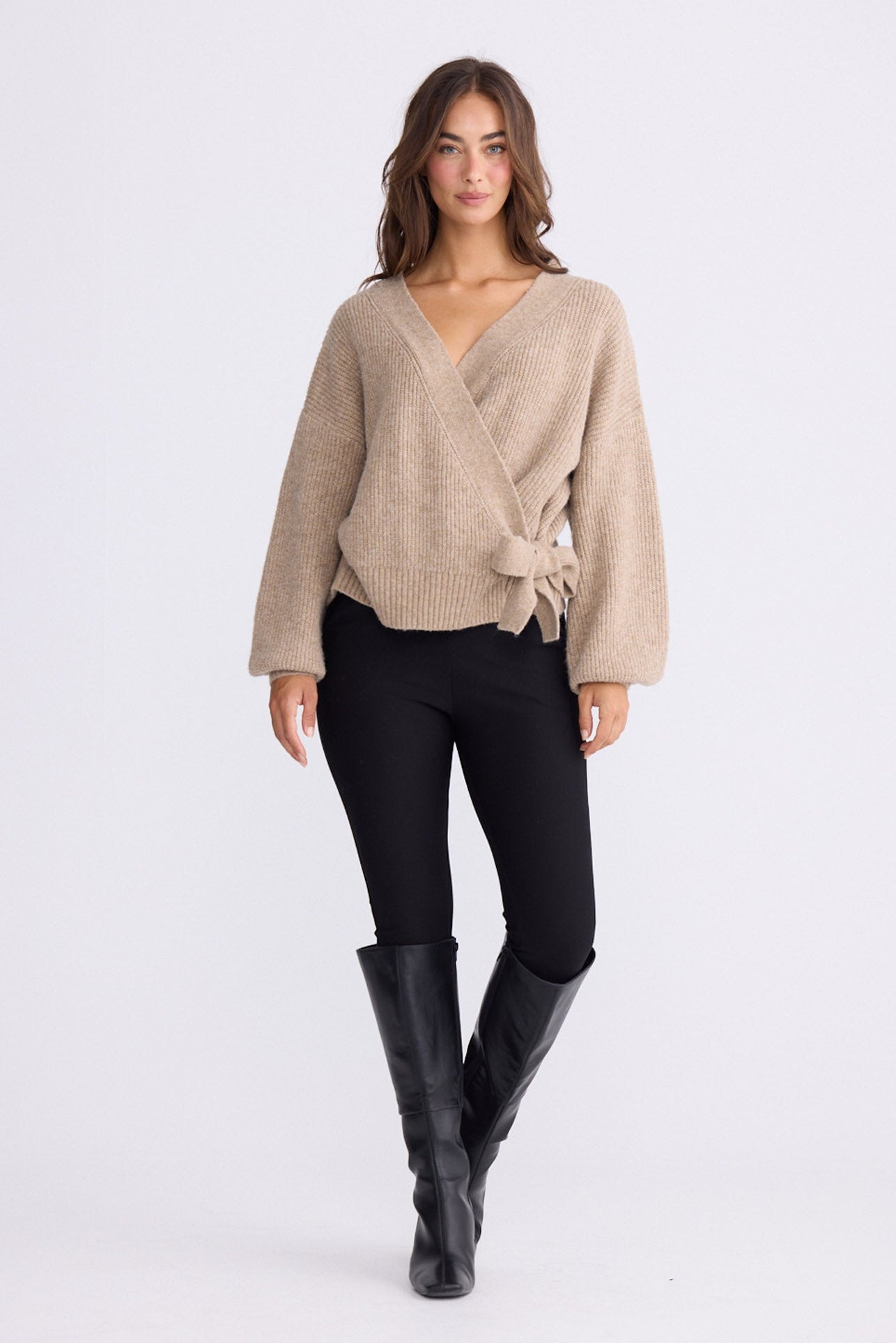 Model wearing Monteith Wrap Knit in beige with V-neck and wrap front, front view on white background