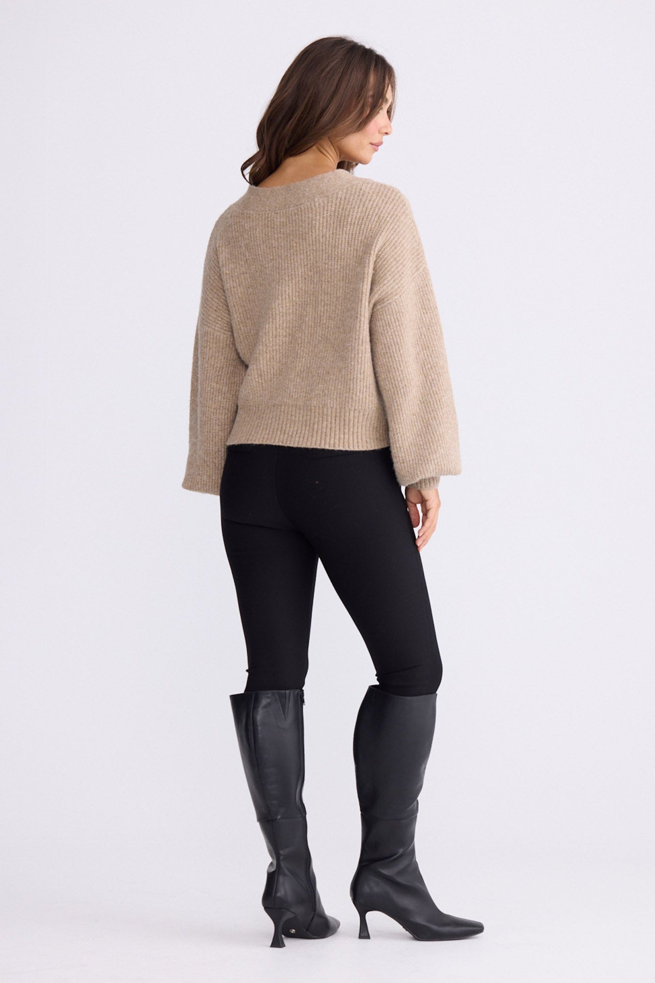 Model wearing Monteith Wrap Knit in beige with V-neck and wrap front, front view on white background