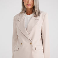 Woman wearing a beige suit with a white background