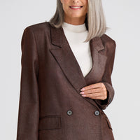 Woman wearing a brown suit with a white background