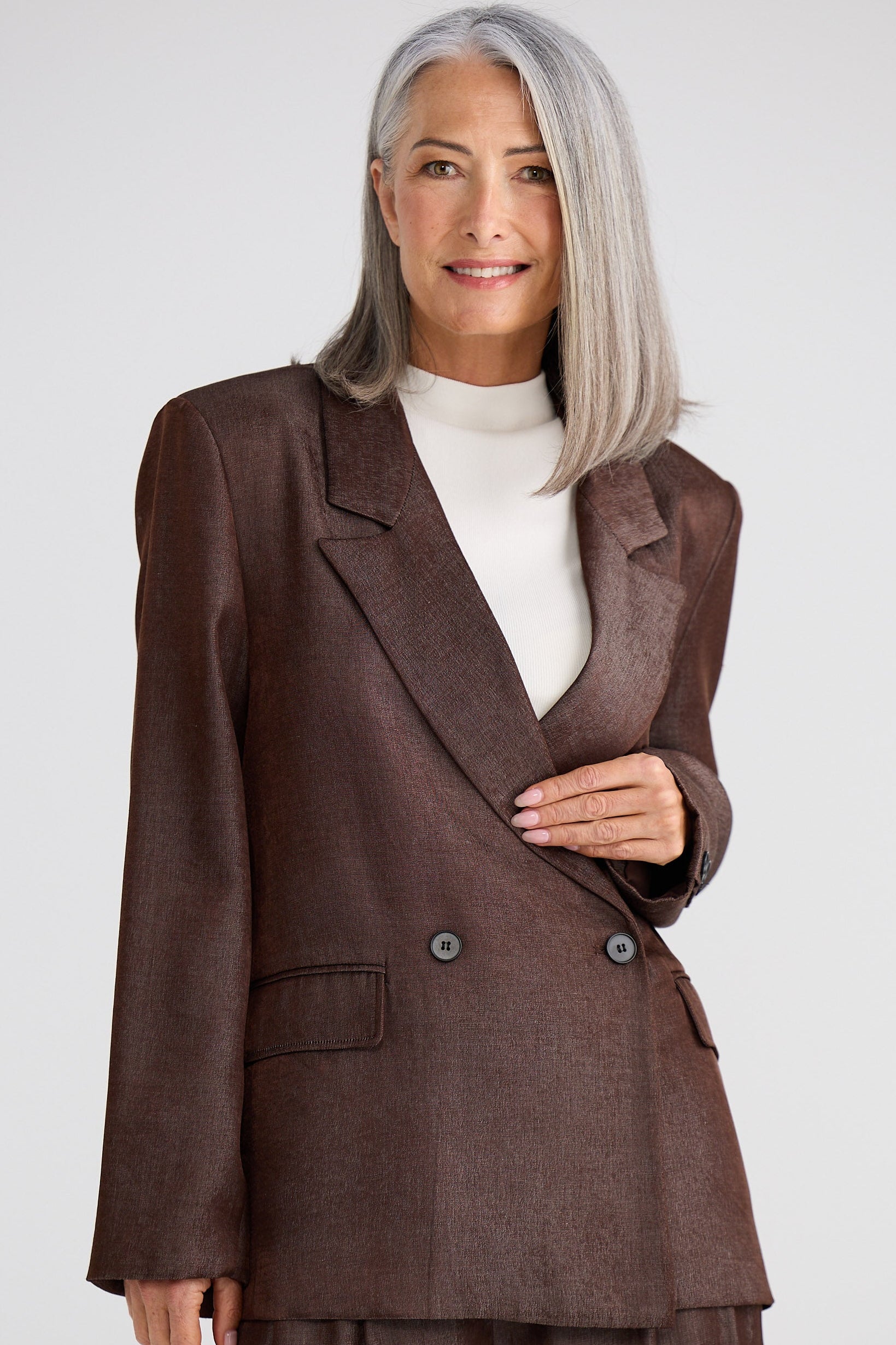 Woman wearing a brown suit with a white background