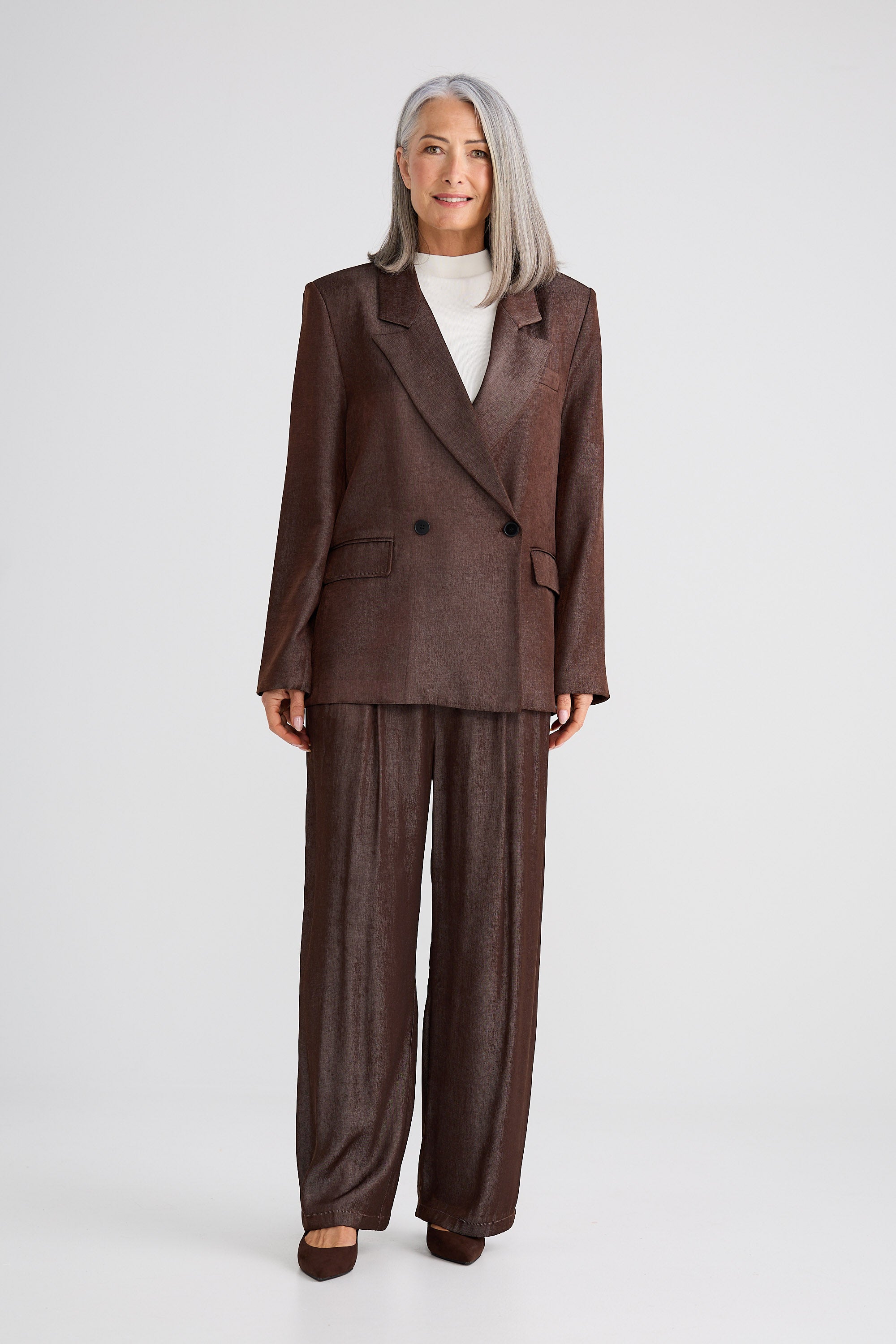 Woman wearing a brown suit on a white background