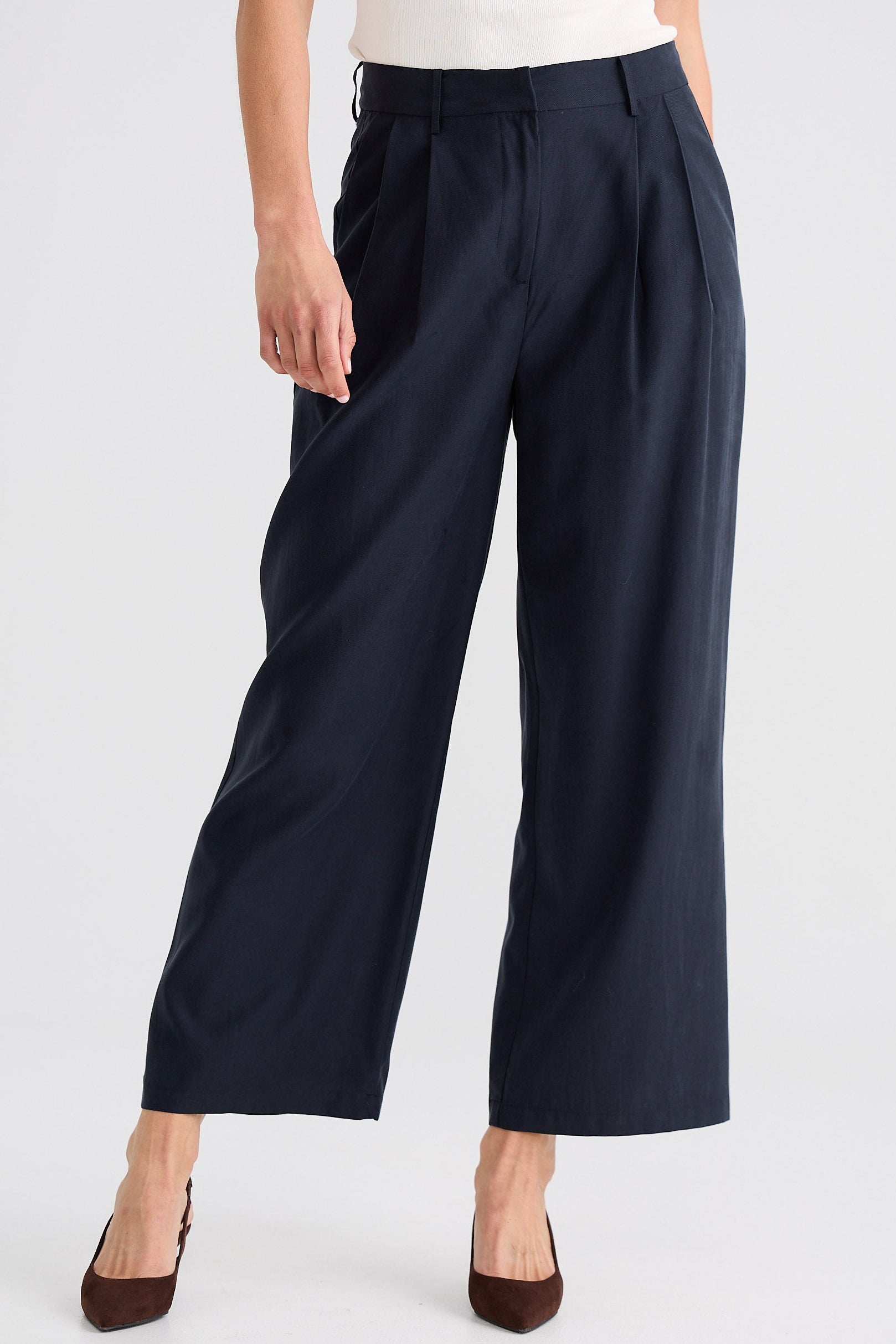 Navy wide-leg pants worn by a person on a white background