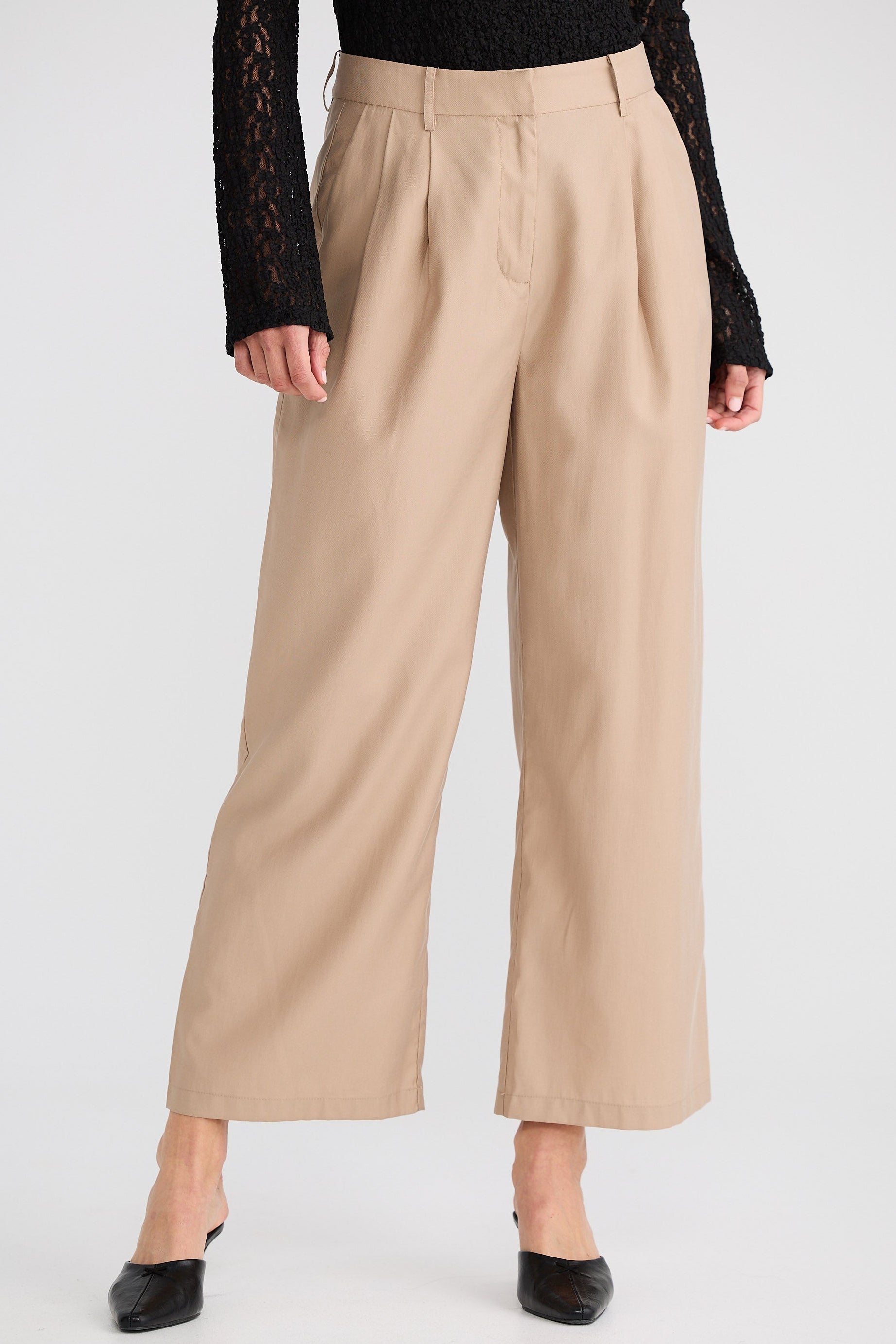 Beige wide-leg pants worn by a person on a white background
