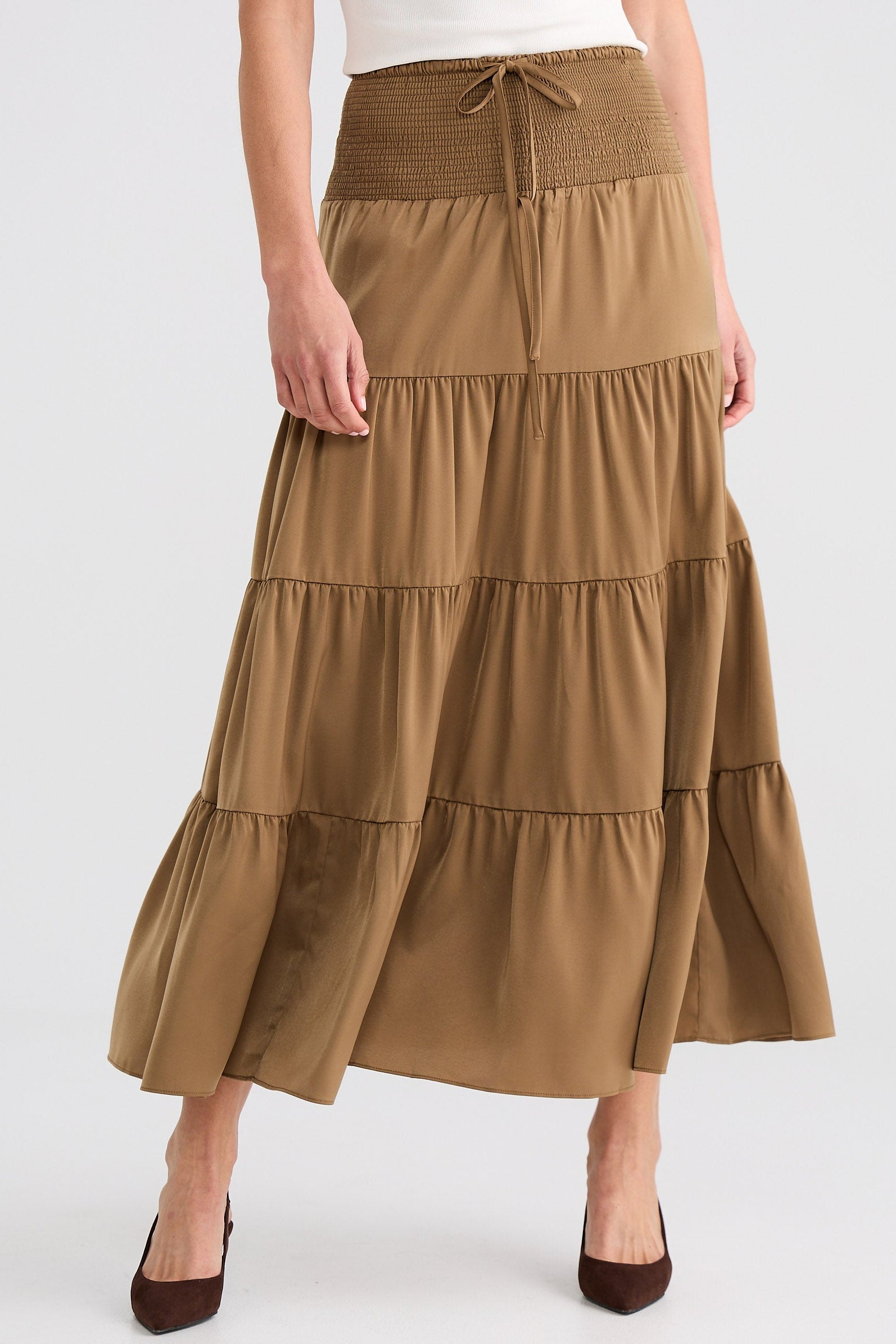 Woman wearing a brown tiered skirt on a white background