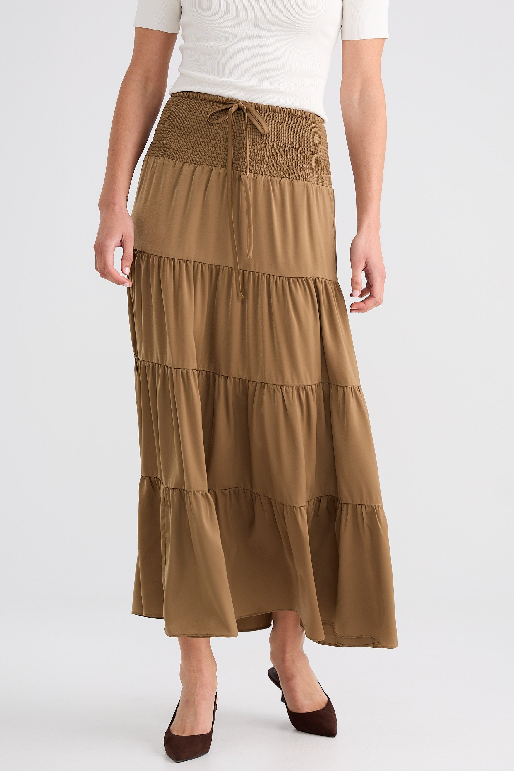 Woman wearing a tiered brown skirt on a white background