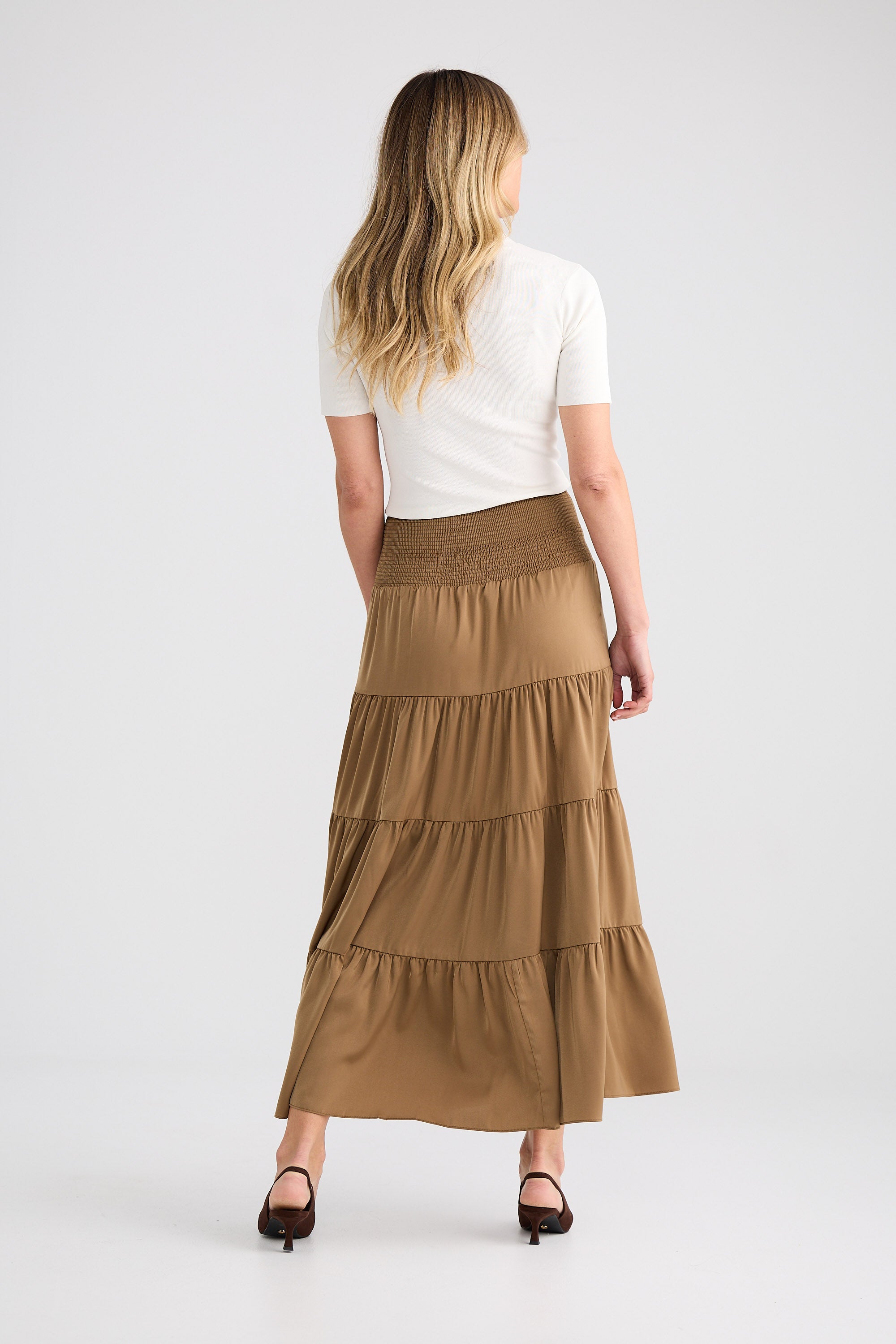 Woman wearing a long tiered skirt on a white background