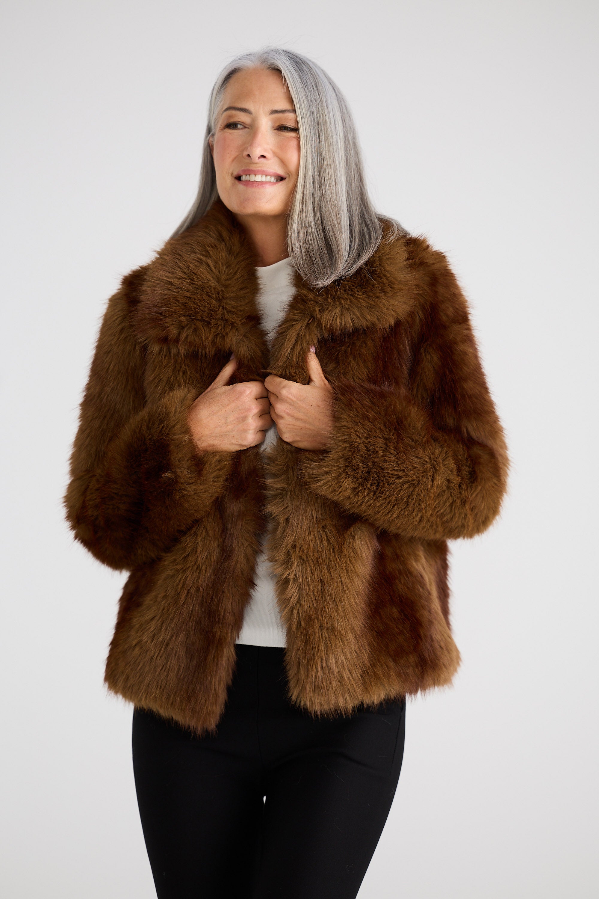 Woman wearing a brown fur coat on a white background