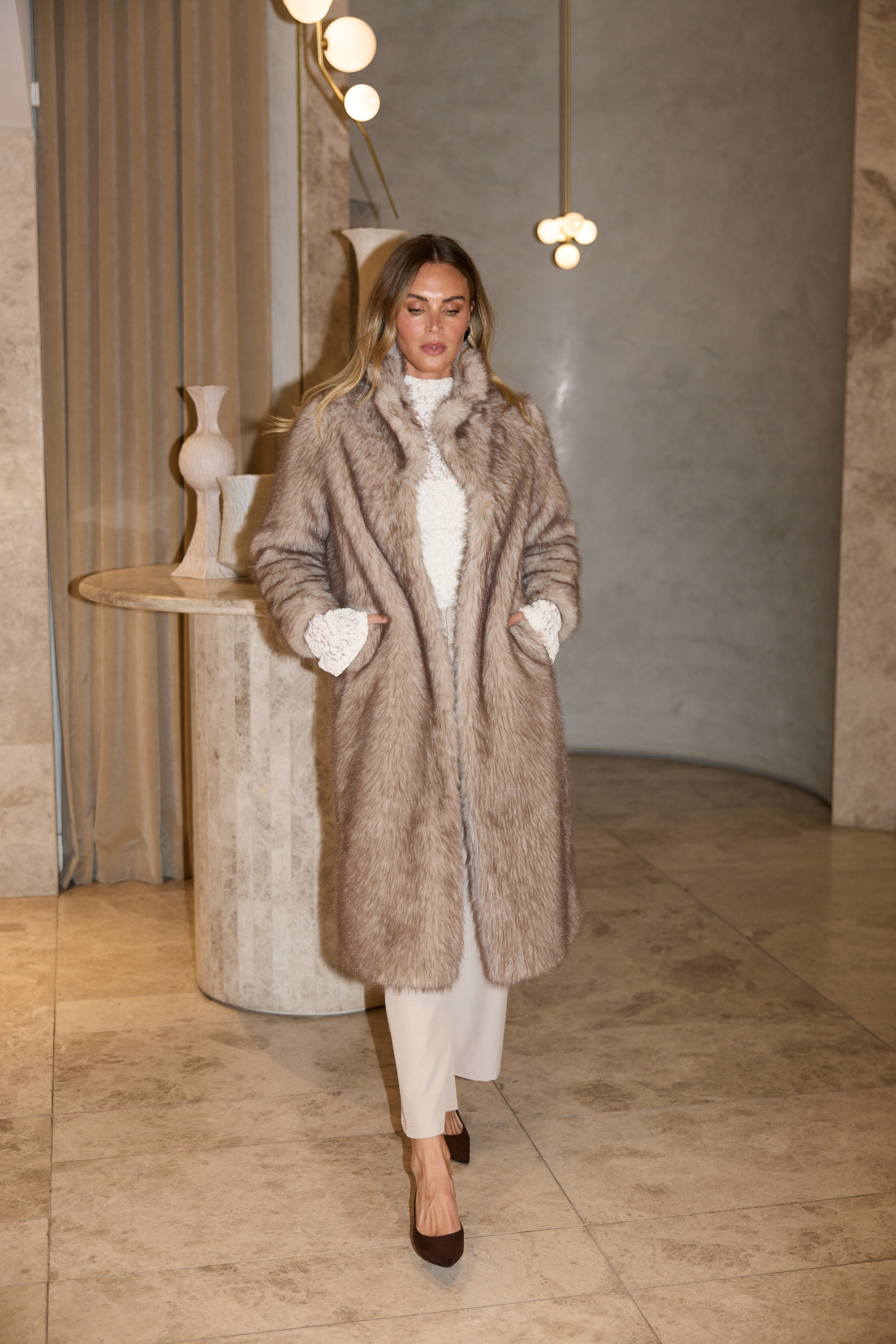 Woman wearing a fur coat in an indoor setting