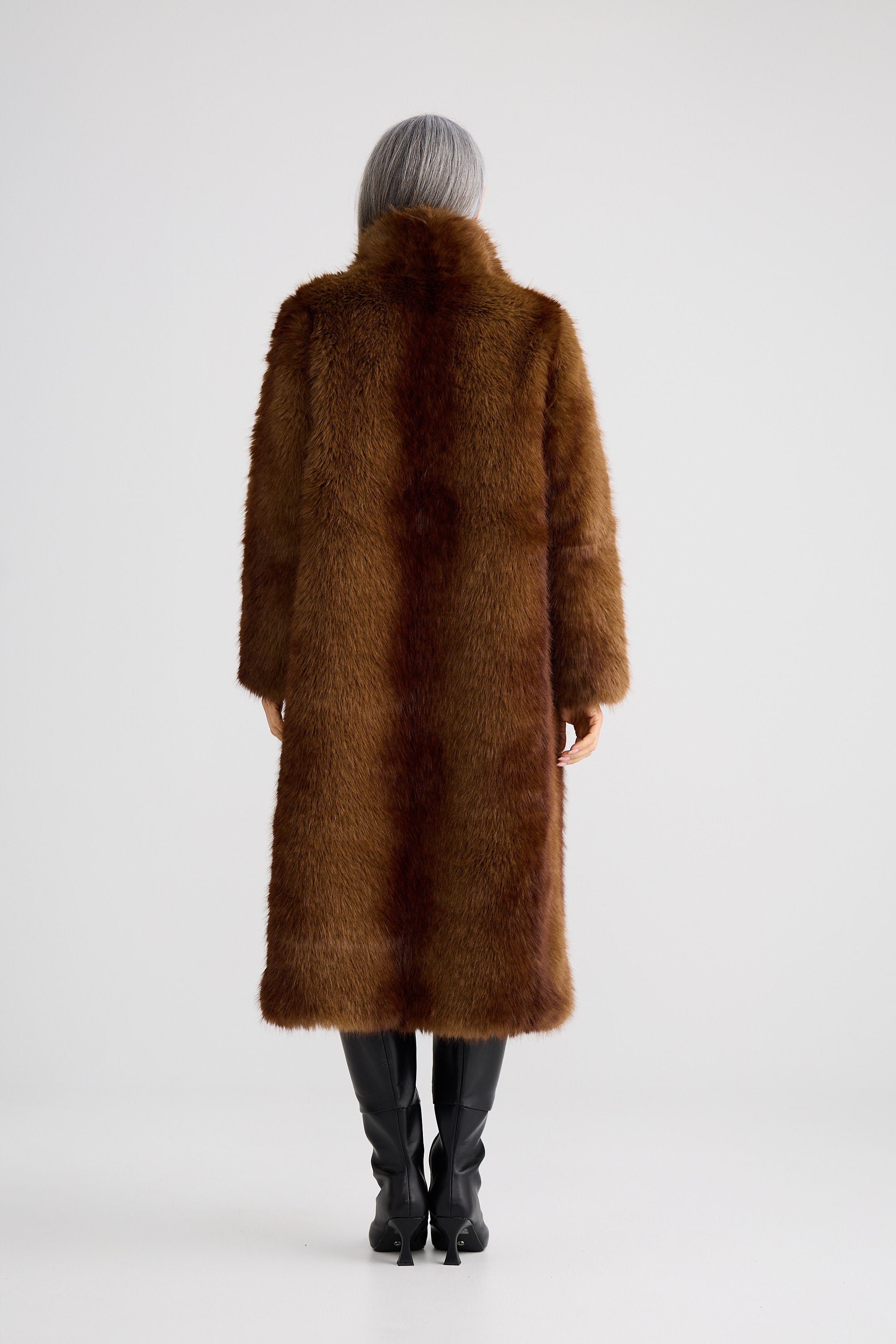Person wearing a brown fur coat on a white background