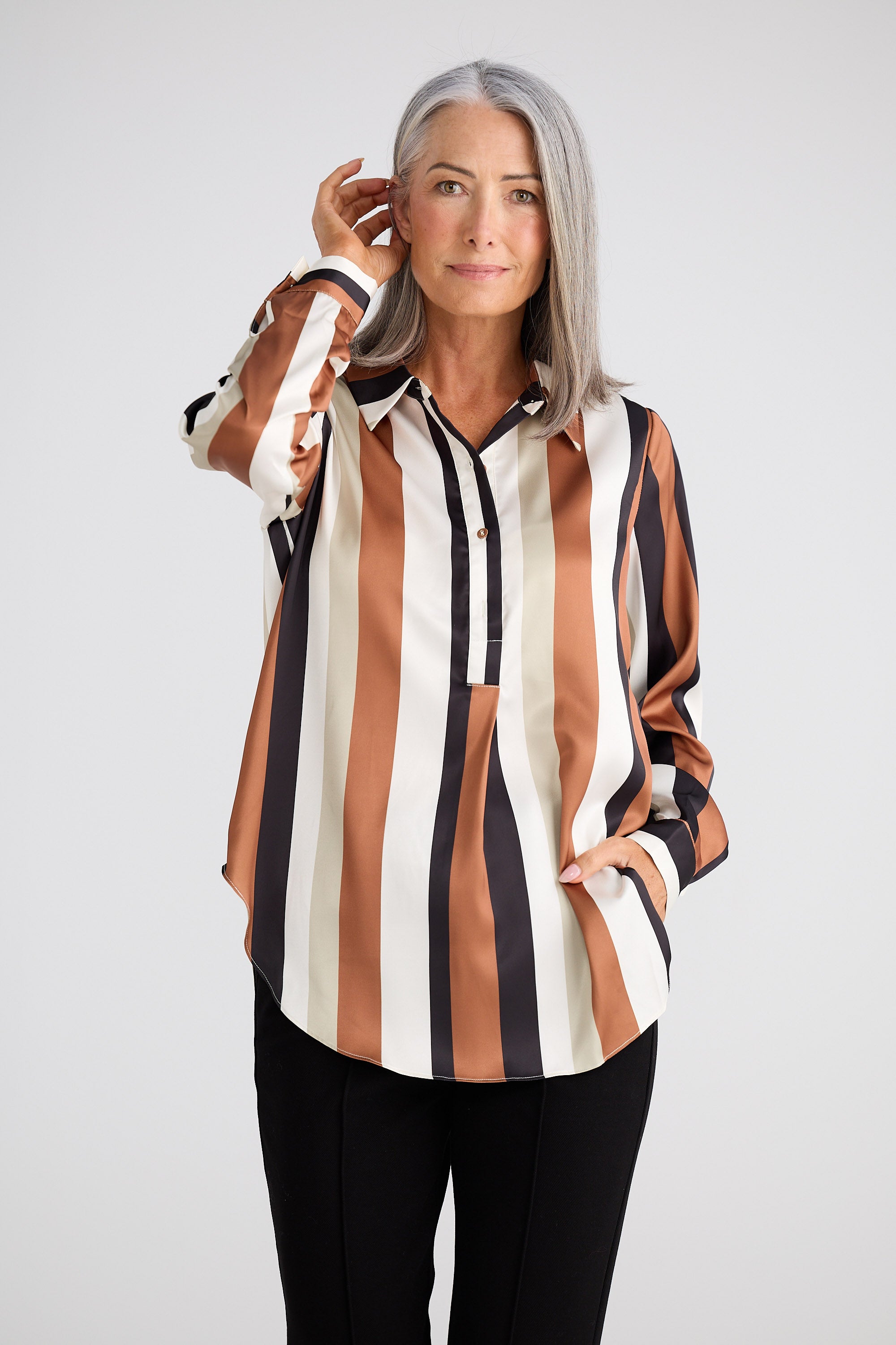 Woman wearing a striped shirt with a neutral background