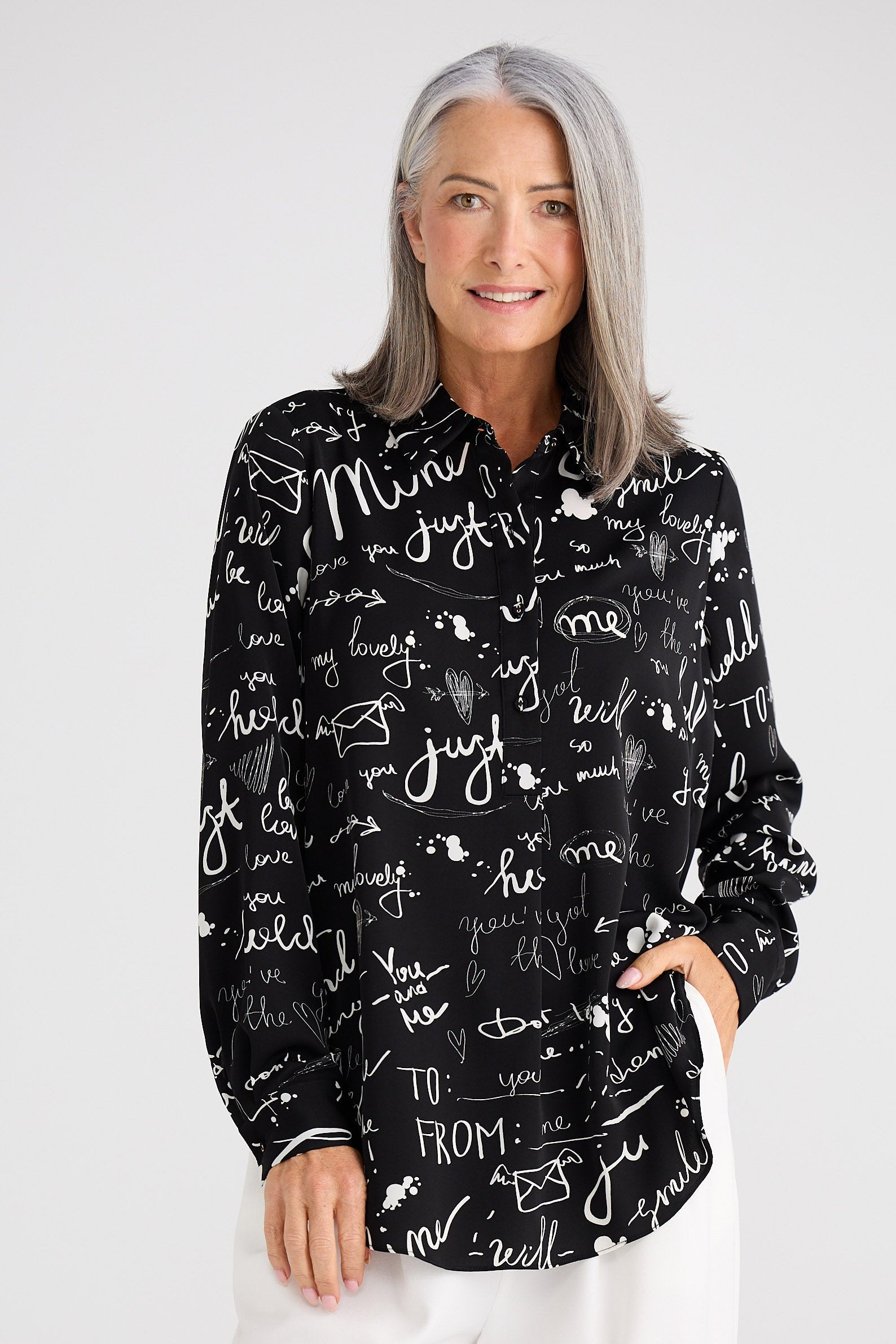 Woman wearing a black shirt with white text patterns on a white background