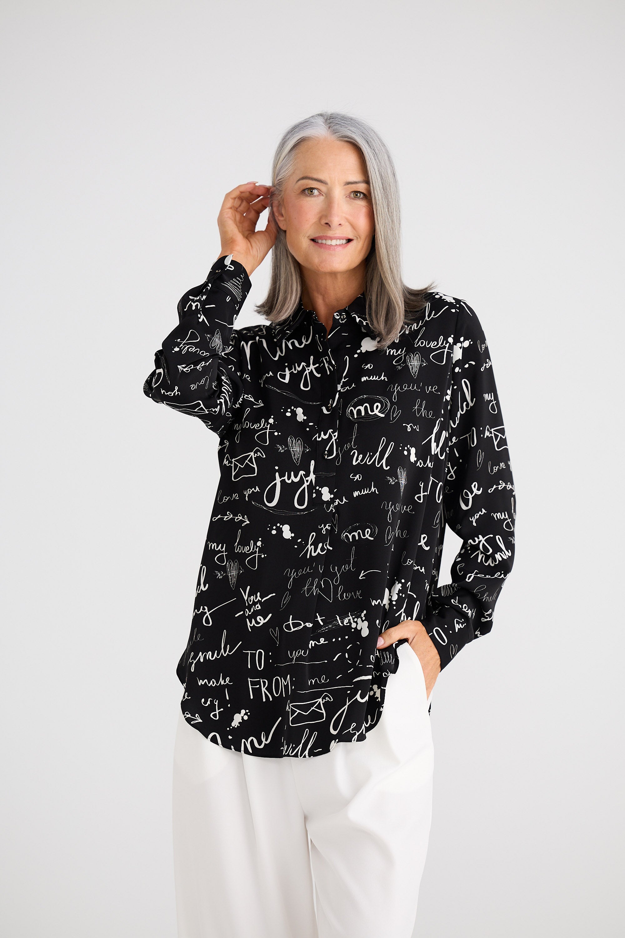 Woman wearing a black hoodie with white text and graphics on a white background