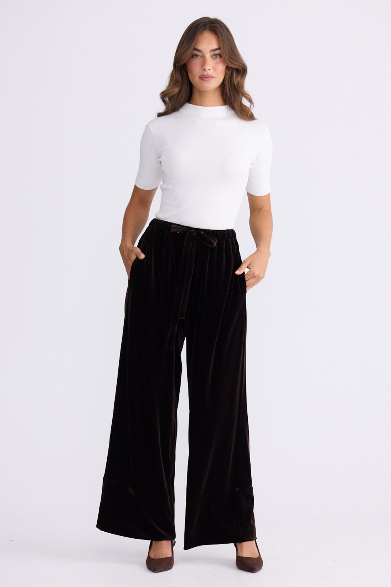 Model wearing Astrid Pant brown pants, relaxed wide-leg fit, alternate studio view on white background