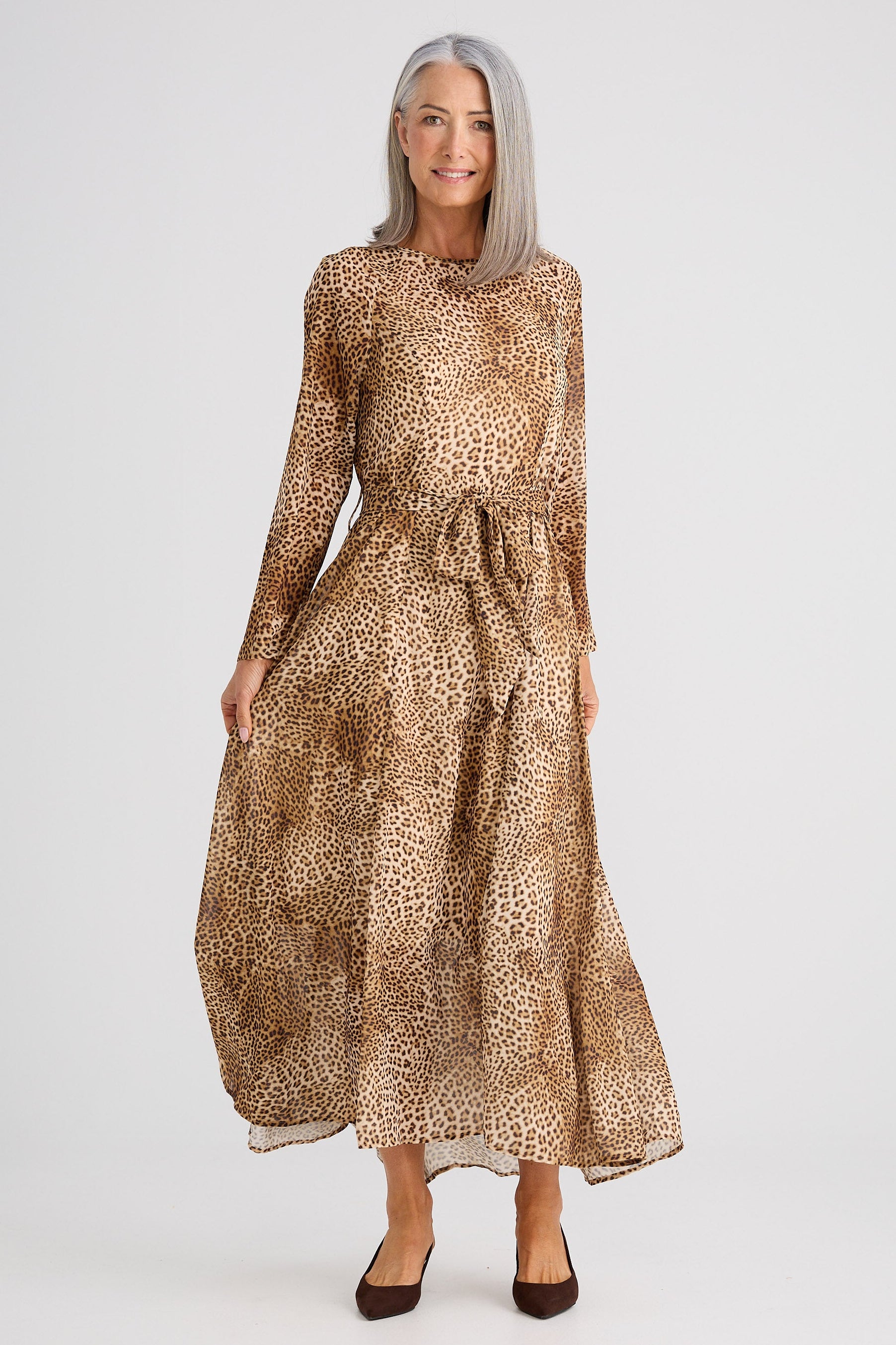 Woman wearing a leopard print dress on a white background