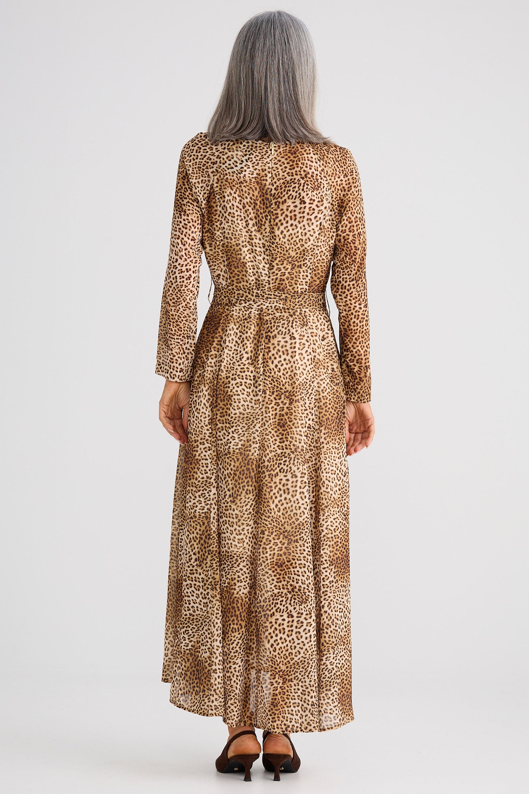 Woman wearing a leopard print dress on a white background